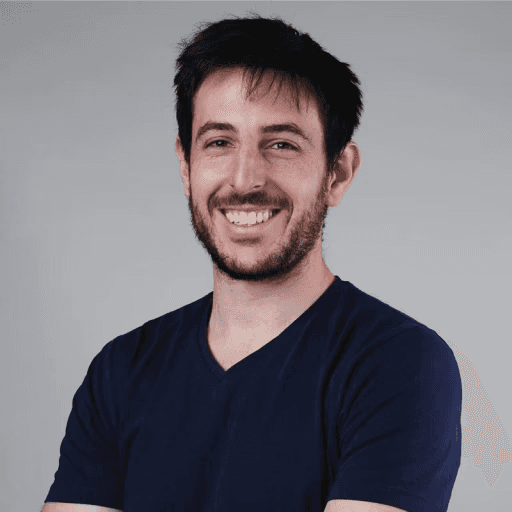 Close-up of a woman in a teal cycling helmet and orange sunglasses, looking at the camera.