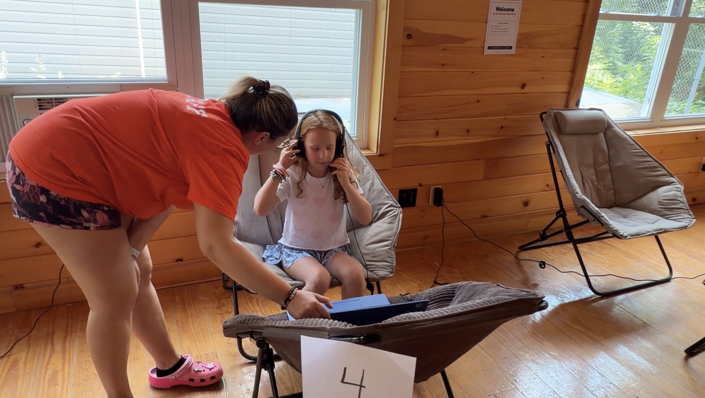 Camper with headphones on a video call at Camp Lenox