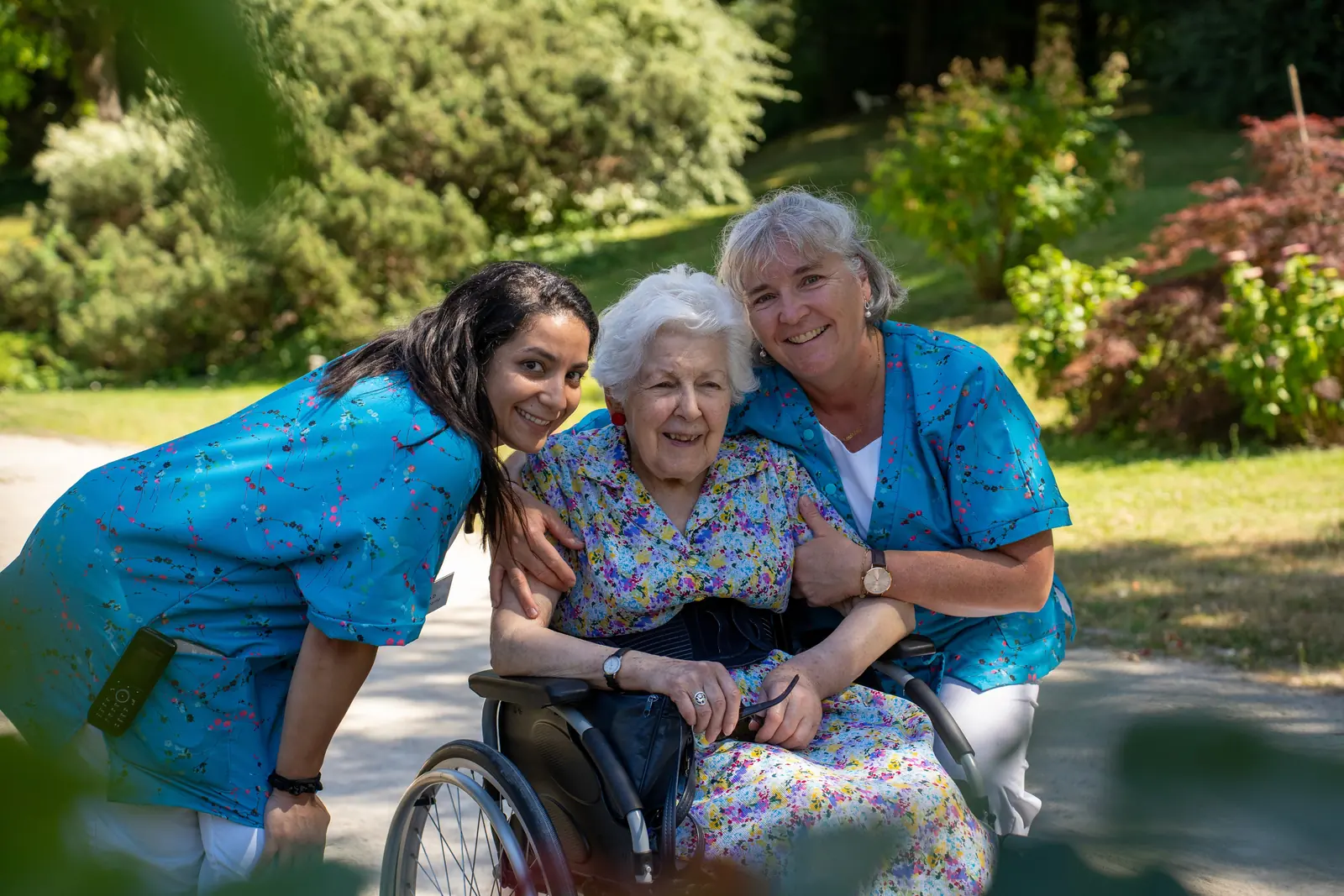 Deux professionnelles Compani accompagnant une résidente dans un jardin