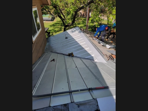 Re-covered 5V metal roof beside the wall in Bulverde, Texas.