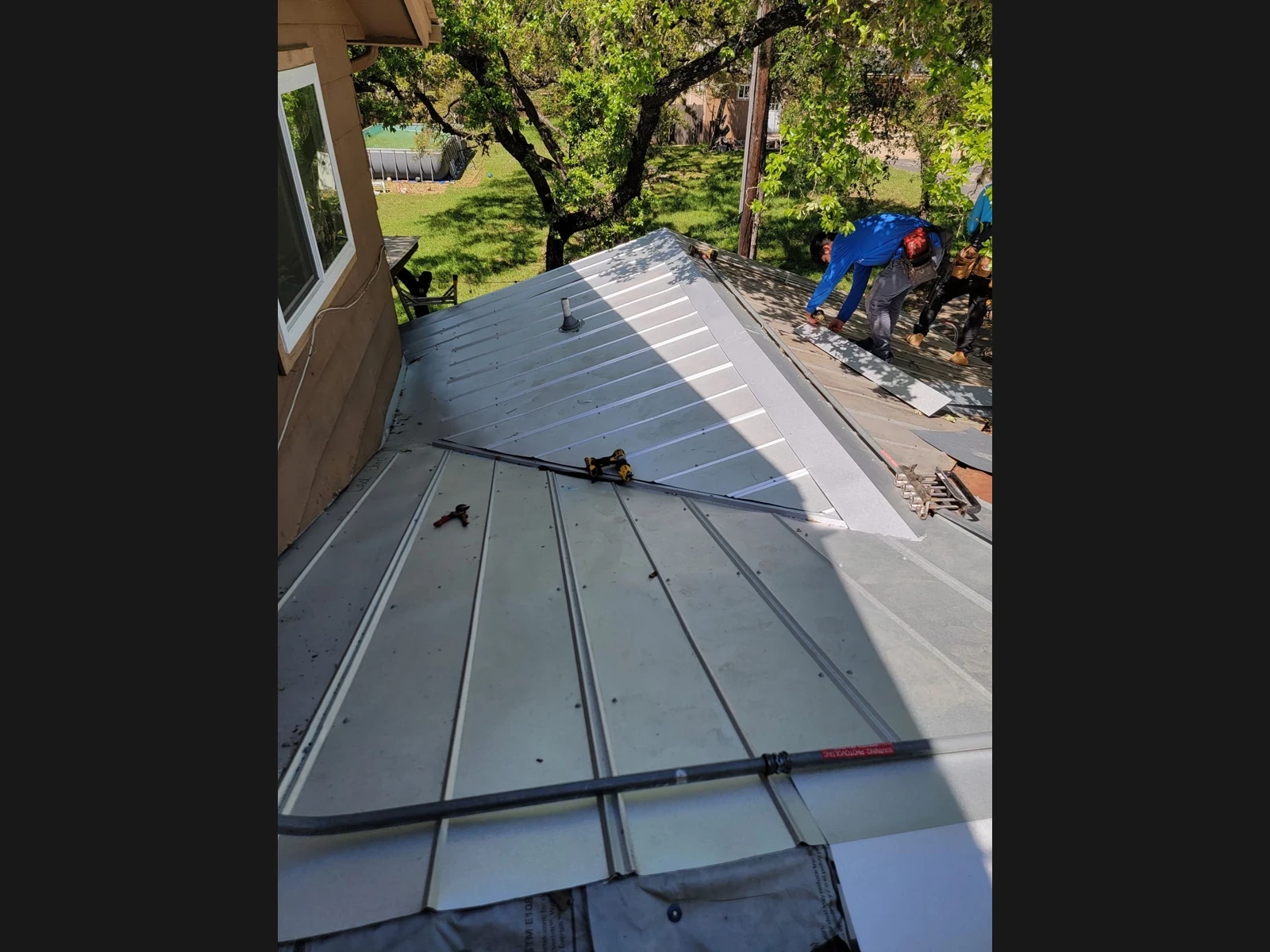 Re-covered 5V metal roof beside the wall in Bulverde, Texas.