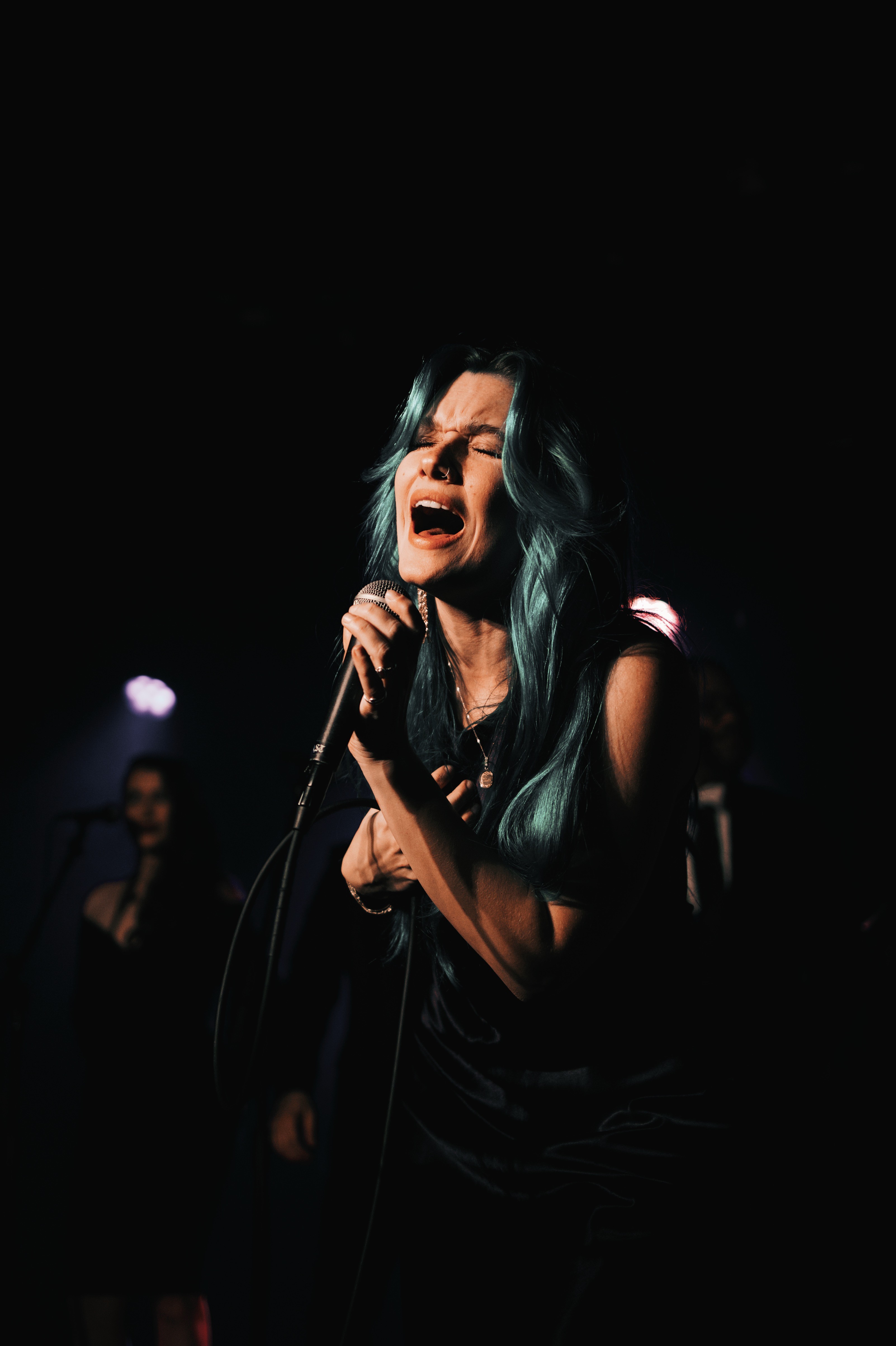 Modern red brick apartment or office building viewed from below against a blue sky, showcasing its geometric architecture with evenly spaced windows and balconies.