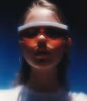A person wearing reflective sunglasses stands against a dark background, exuding a mysterious vibe.