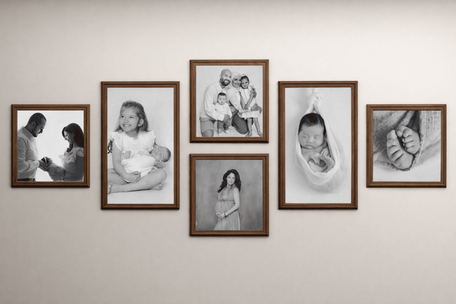 Black and white family photo wall gallery with framed portraits