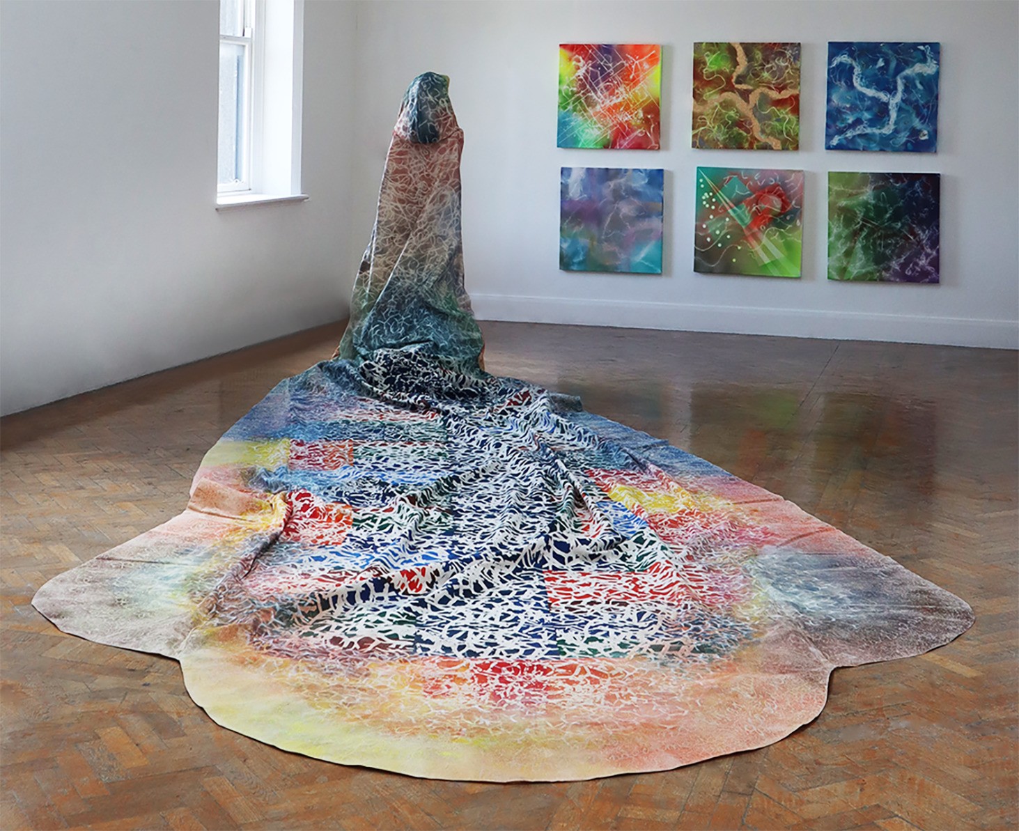 Screen printed cloak with paintings in background