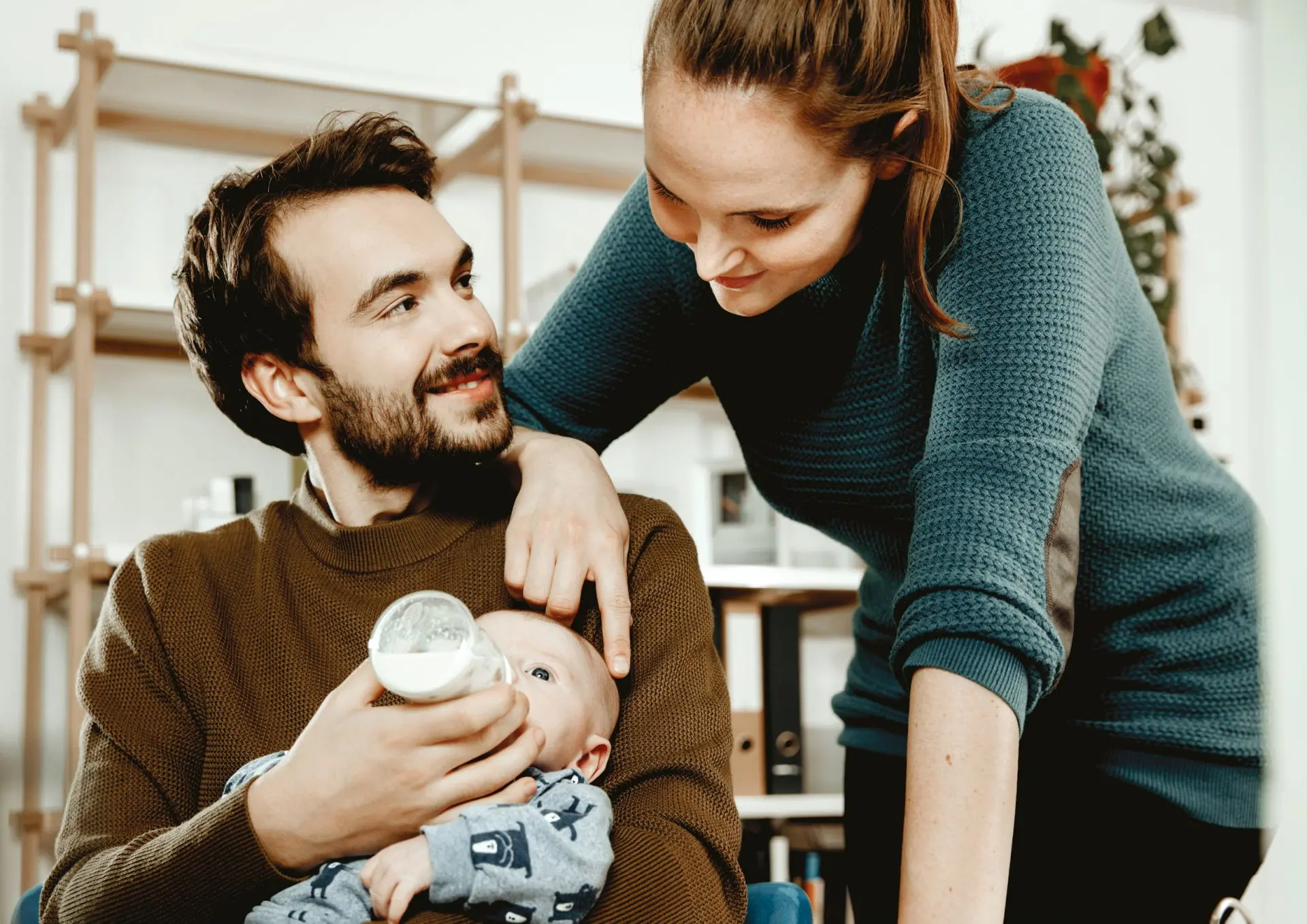 Image de parents donnant le biberon a leur bébé avce le lait Novalac, marque proposée par la pharmacie d'Ecquevilly