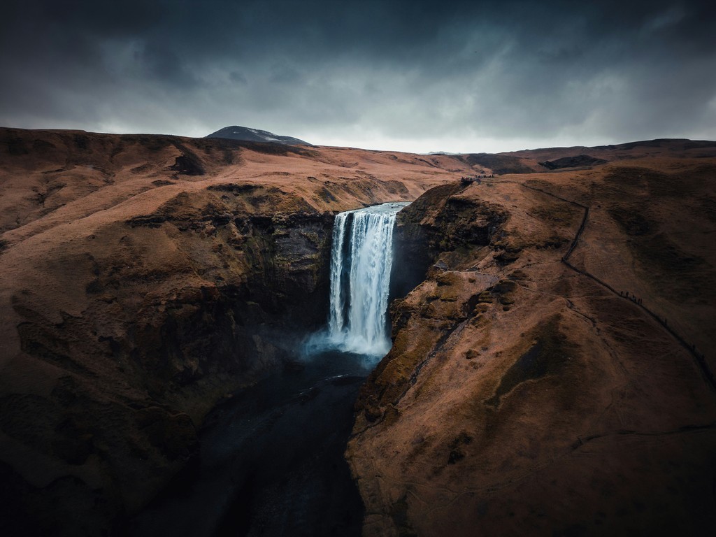 A waterfall surrounded by brown grassy hills