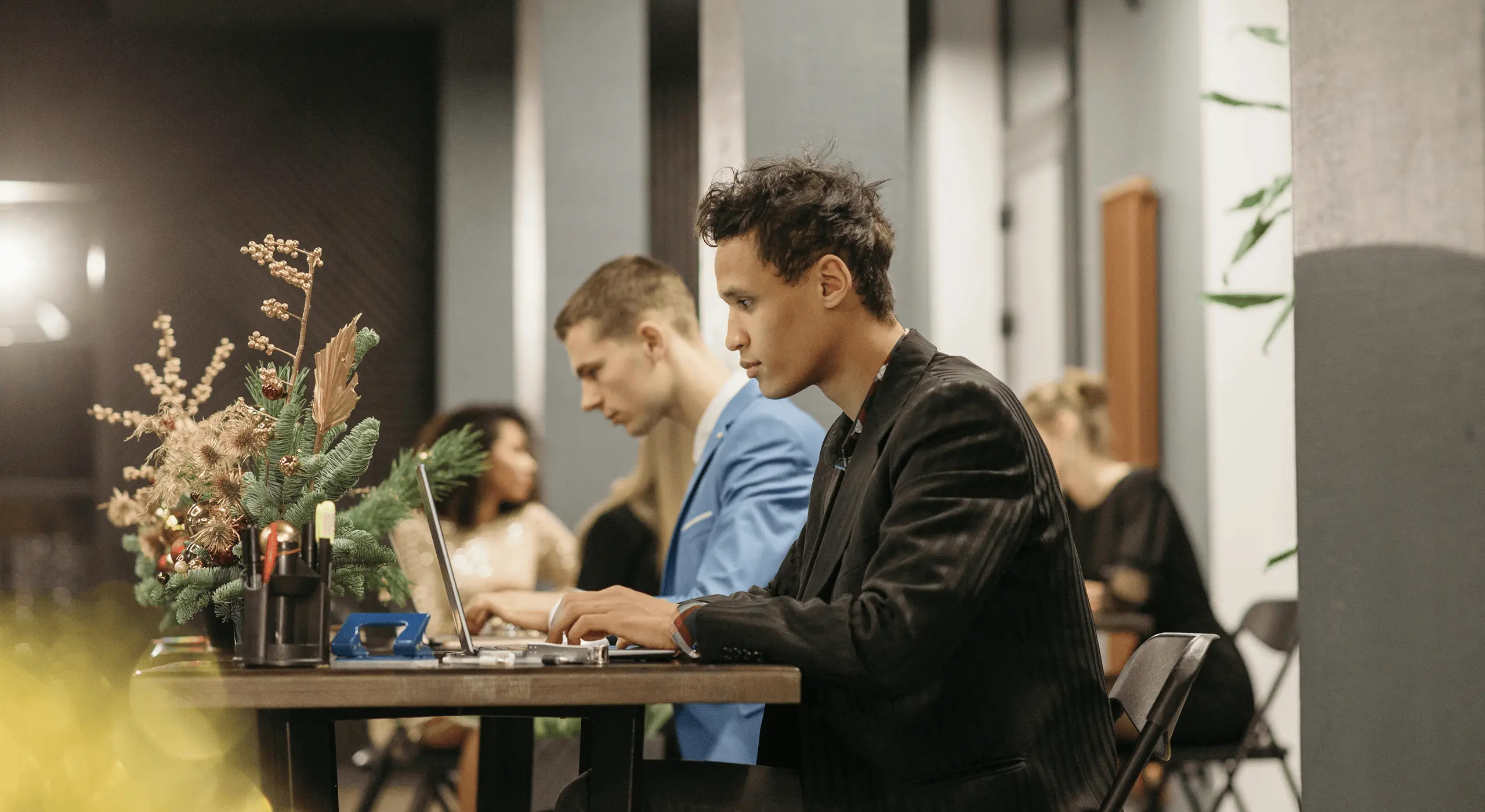 Two men working on laptops in a modern office.