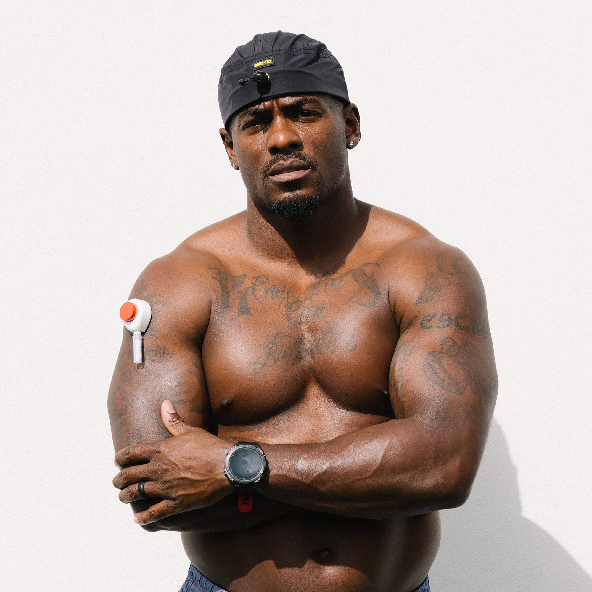 Man standing with arms crossed looking at the camera doing the rythm blood collection on his upper arm