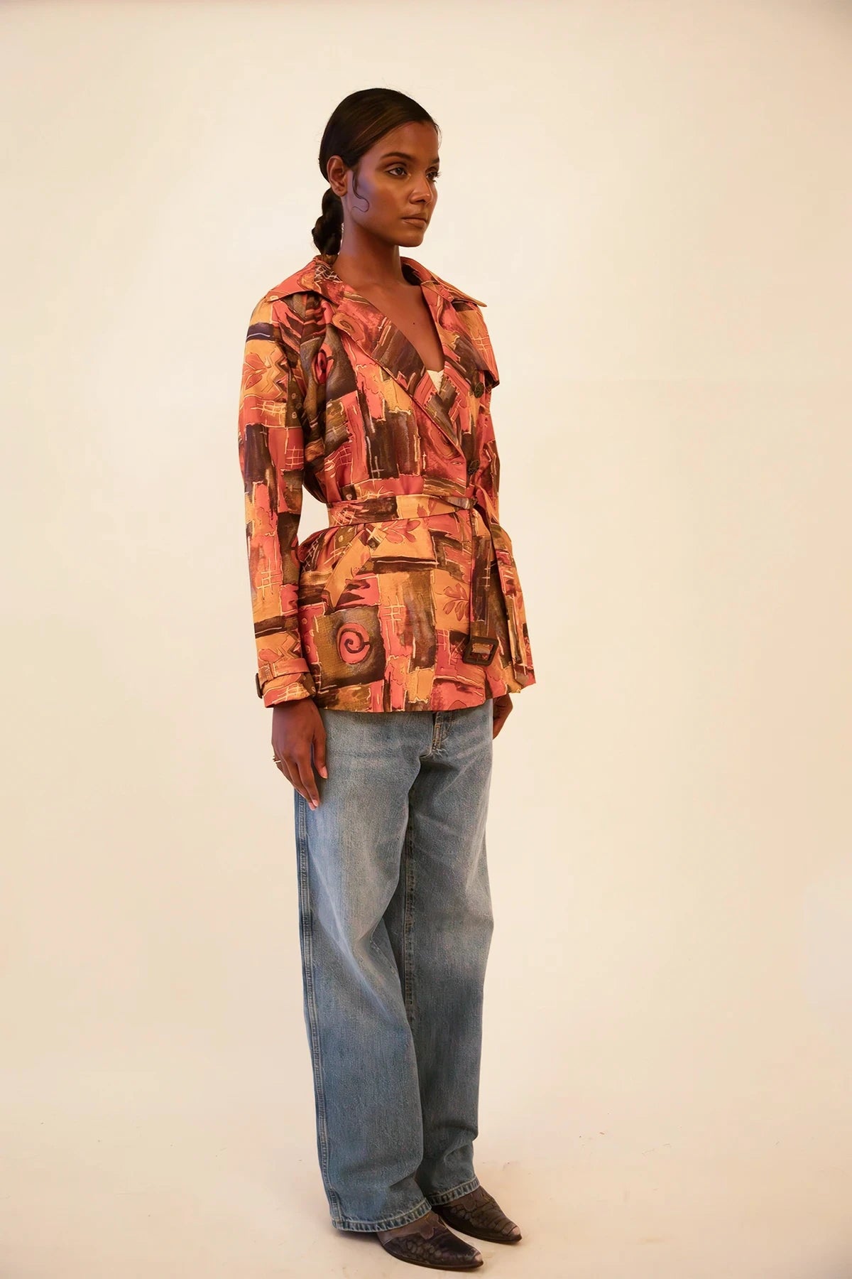 Cropped trench coat crafted from upcycled abstract print silk, featuring a relaxed fit and lightweight structure.