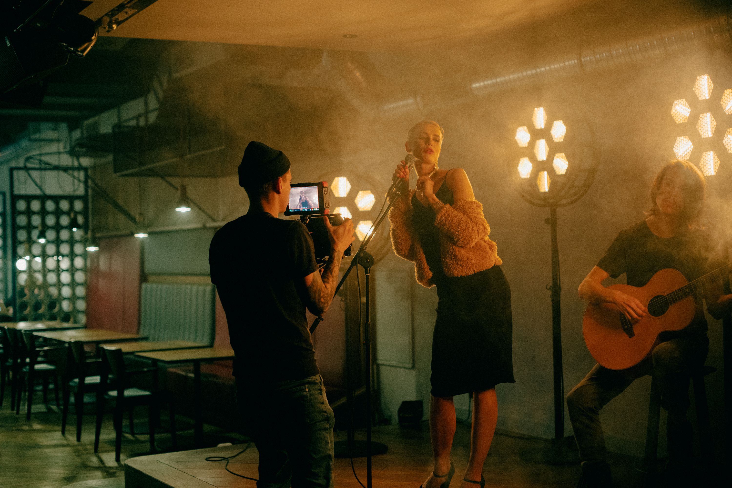 A close-up of a person wearing green-tinted glasses, with a serious expression and smooth skin.