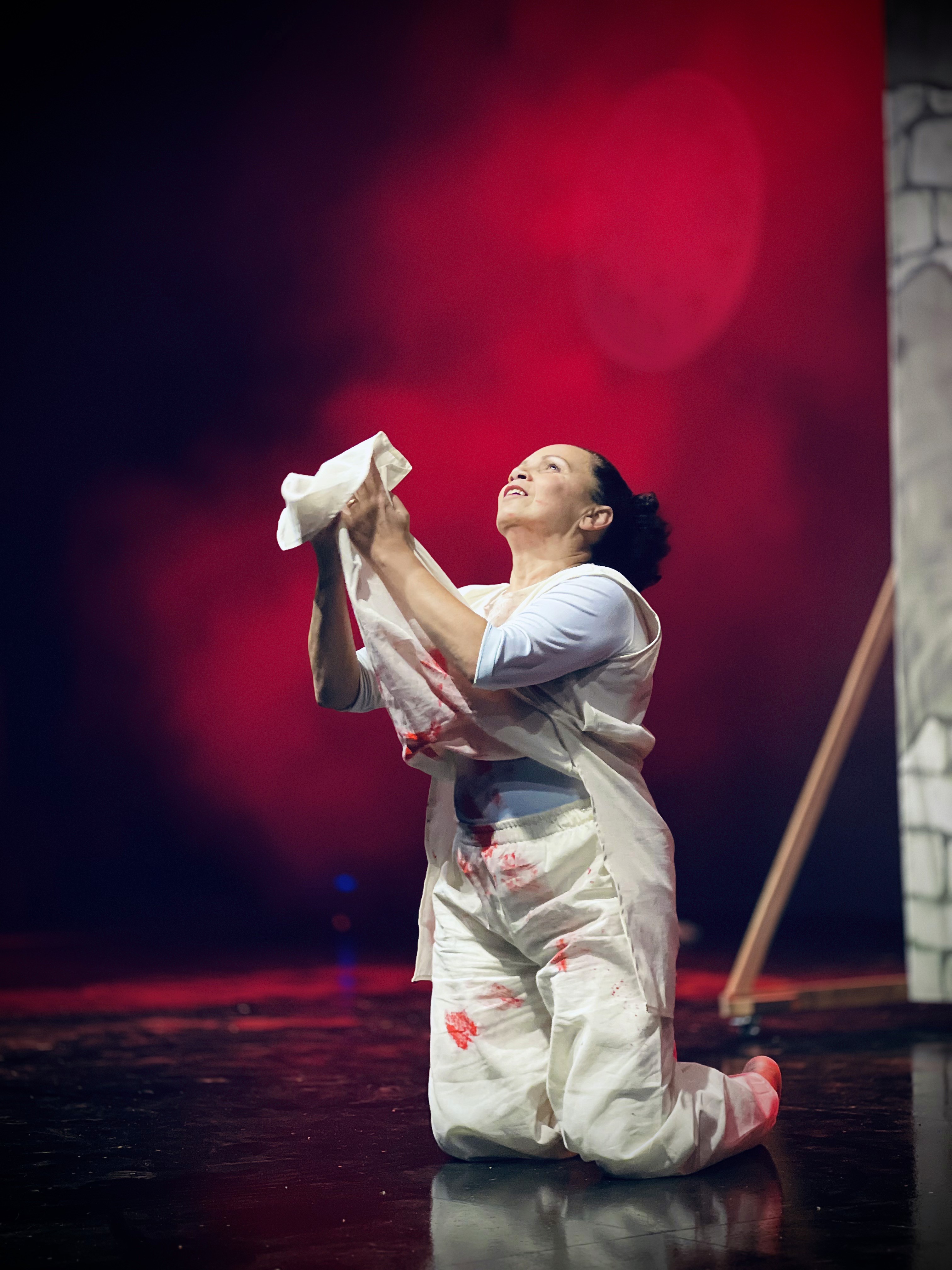 person discussing while standing in front of a large screen in front of people inside dim-lighted room
