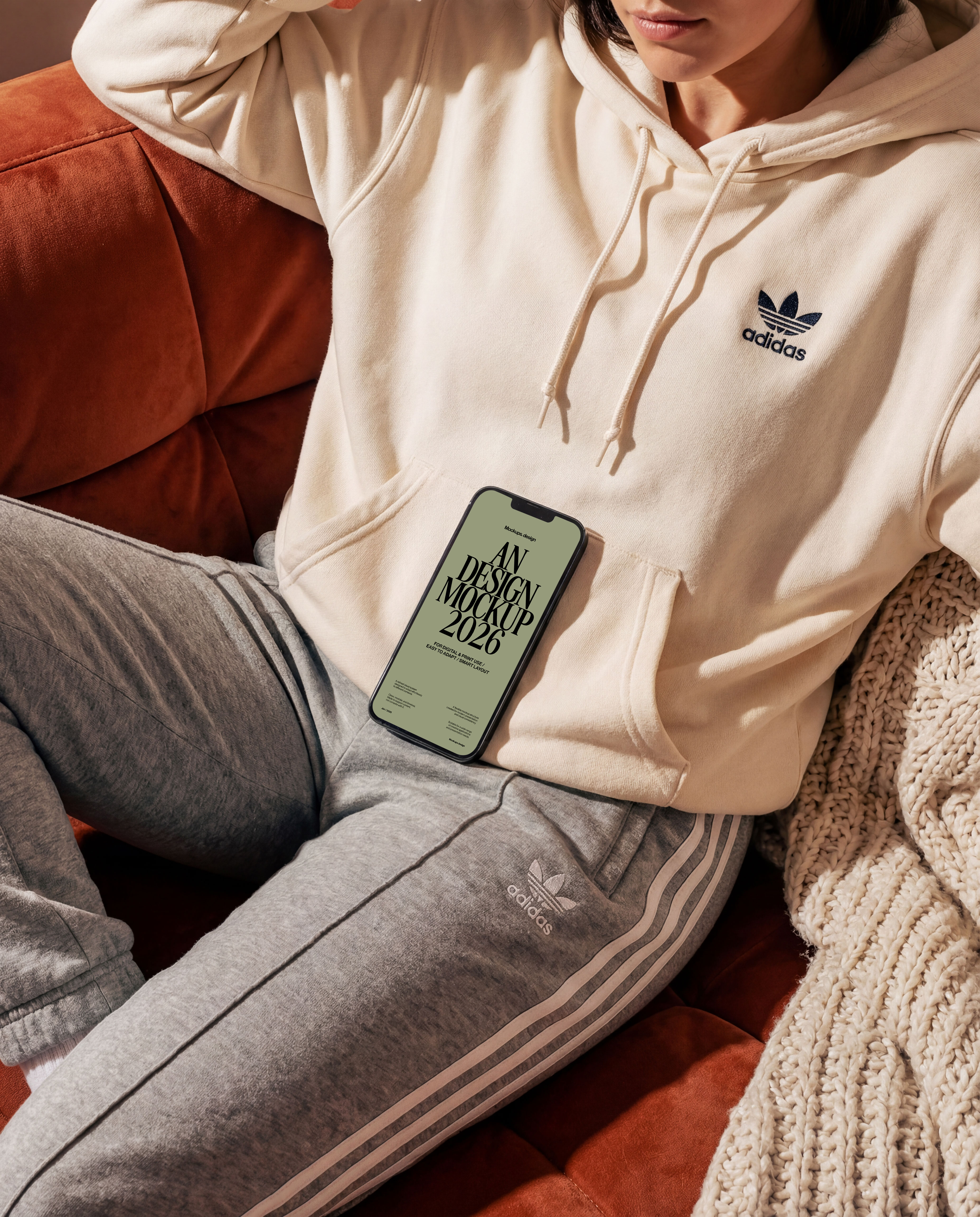 Woman using iPhone 16 mockup on couch, casual home scene