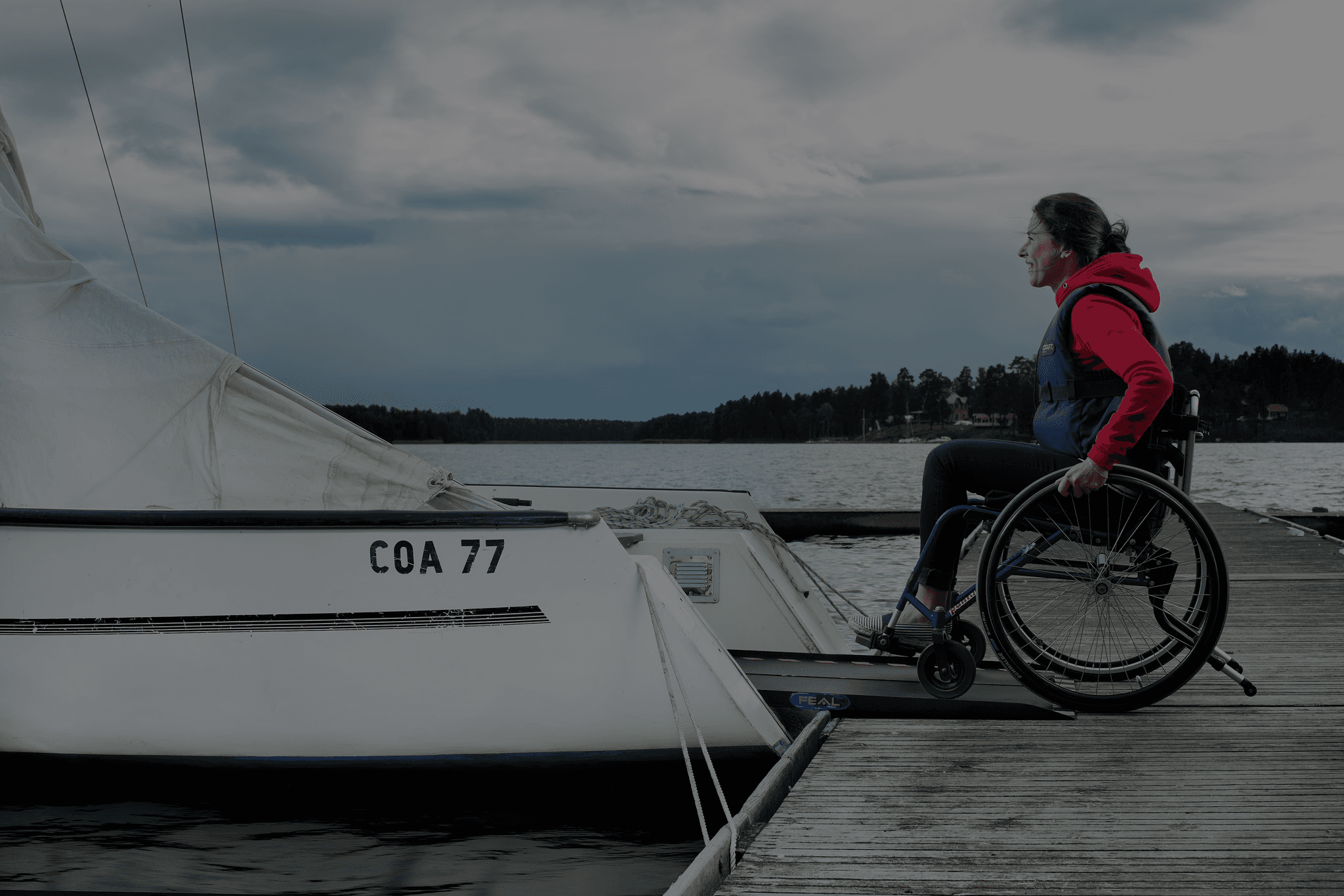 manual wheelchair boarding a sailing boat with the use of a ramp