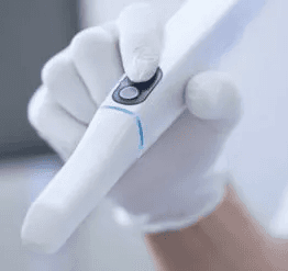 Gloved hand holding a 3Shape TRIOS 5 wireless intraoral scanner