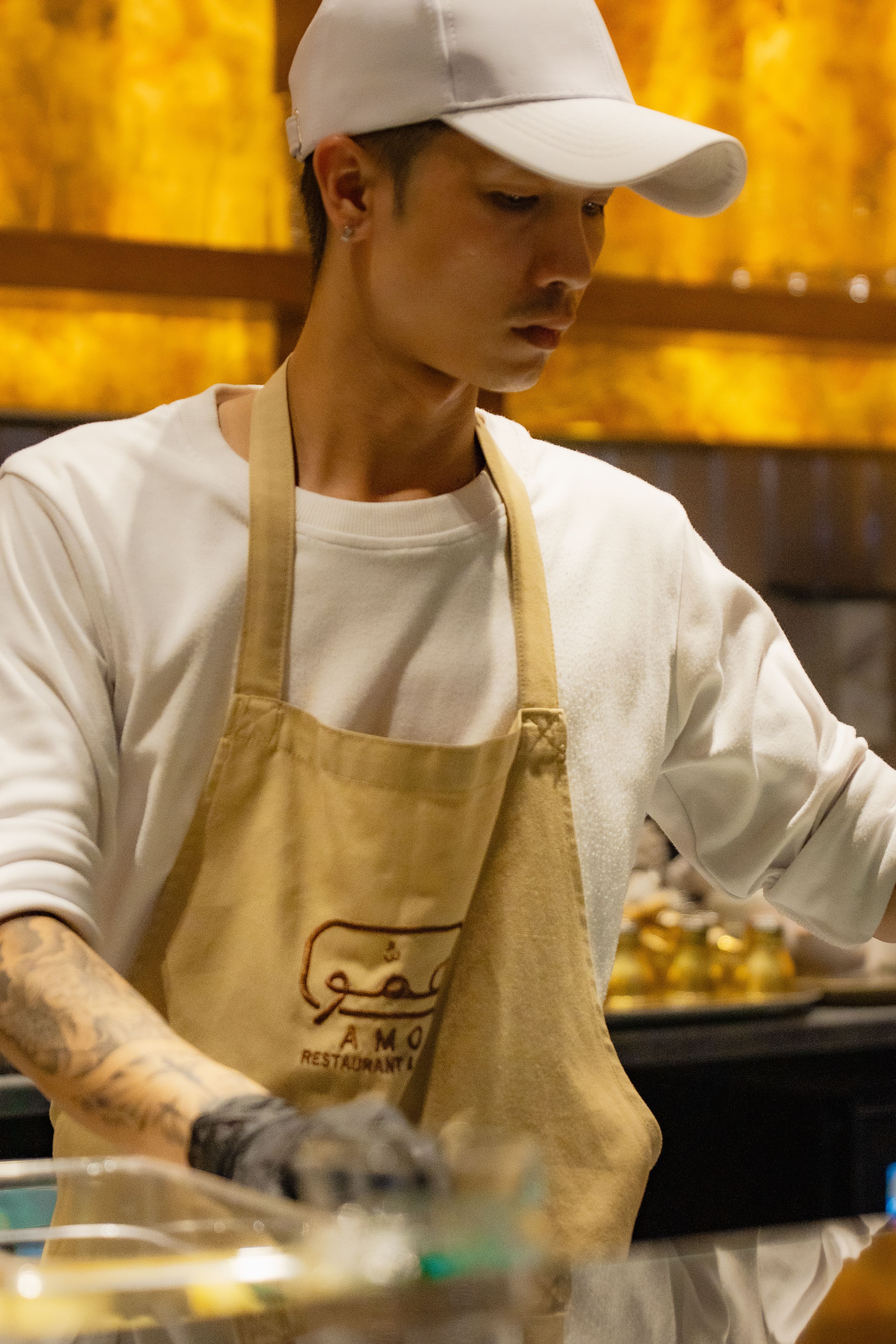 参加 SWT 项目的餐厅岗位实习生在吧台专注开展餐食饮品相关作业