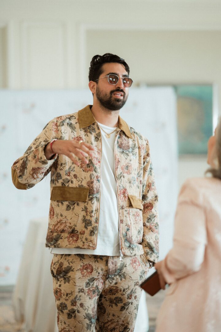Young woman in a white shirt with a colorful gradient print, against a plain background.