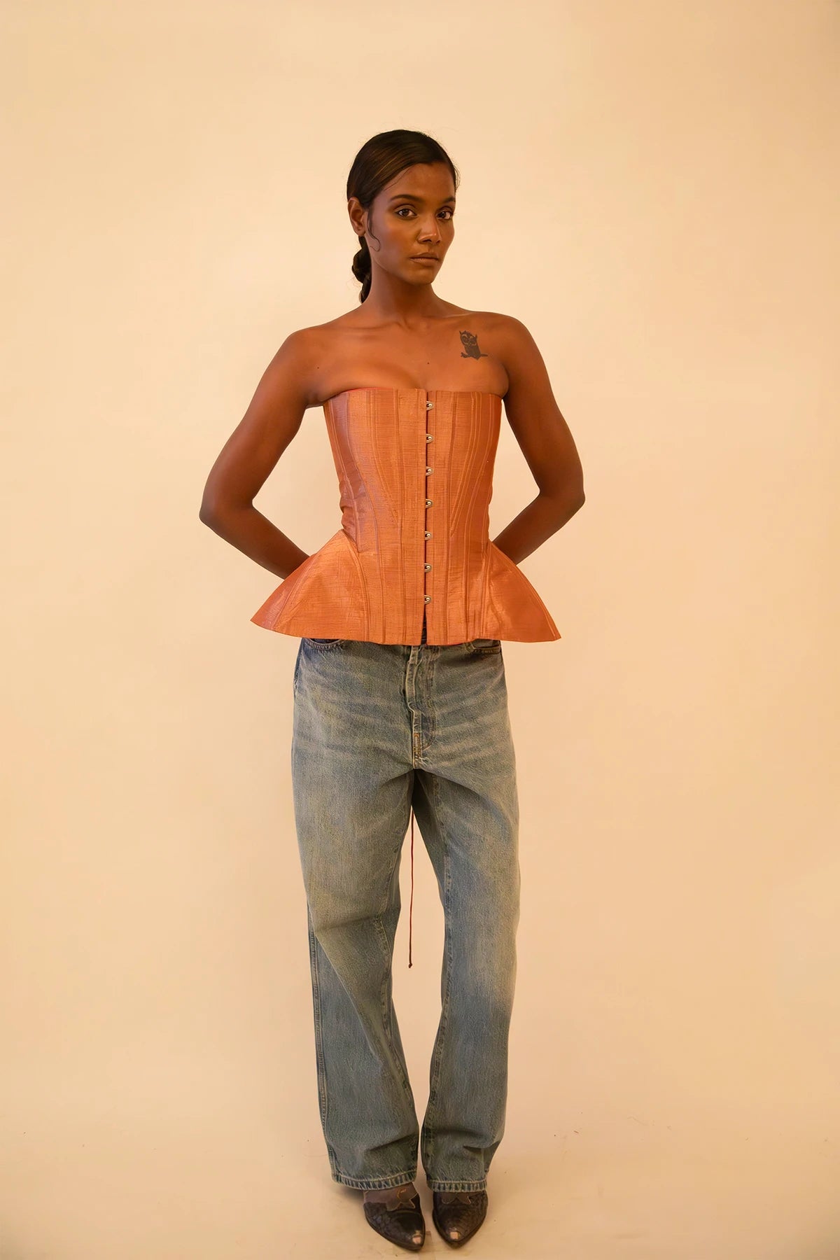 Bell corset handcrafted from a vintage rose gold silk sari, featuring front closure and adjustable lace-up back, designed for a structured fit and celebrating mindful craftsmanship.
