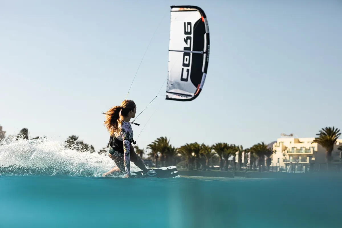Woman kiting with Core Kites gear near the coastline and palm trees