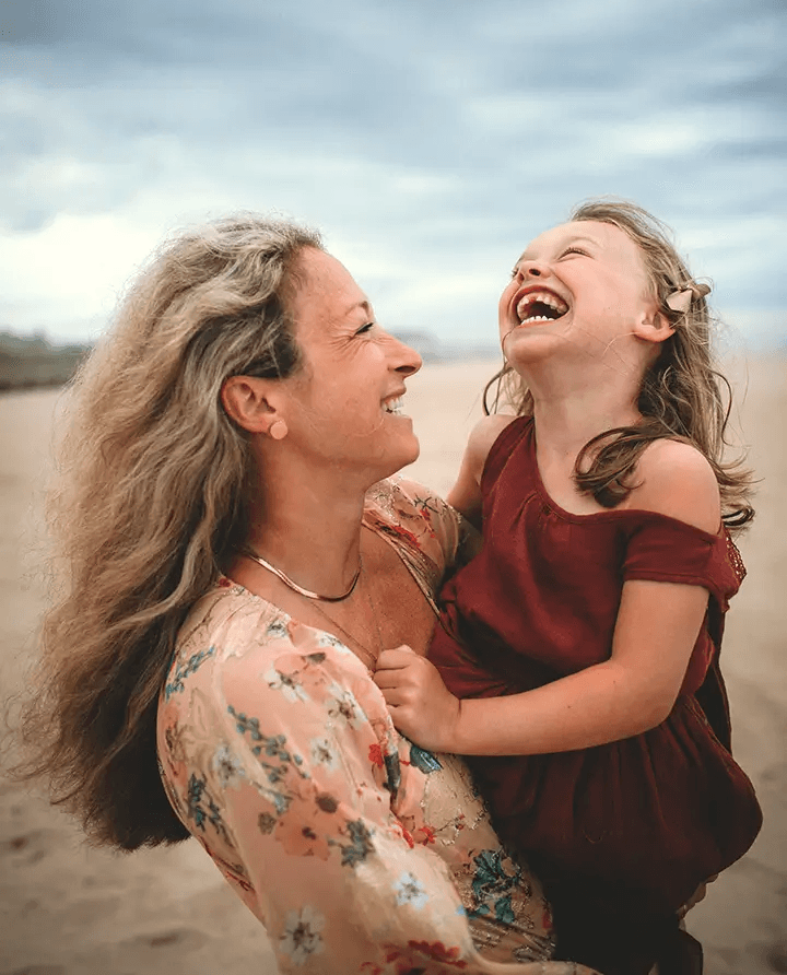 Mother and daughter laughing during a warm, playful family session in San Diego.