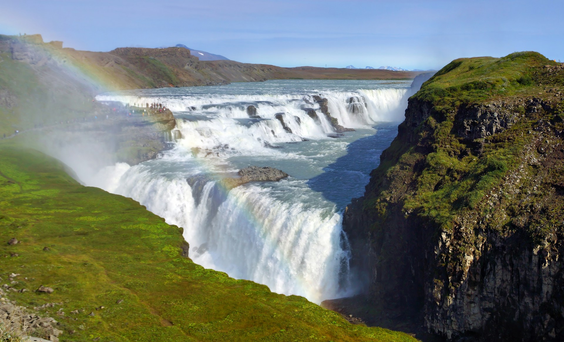 Gullfoss waterfall in the Golden Circle, Iceland, with a rainbow above powerful cascades.