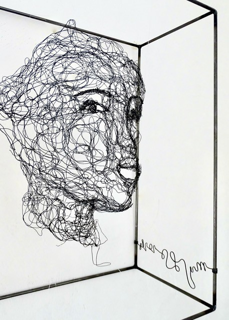 Sculpture en fil de fer représentant le visage d'une femme dans un cadre en fil de fer, vue détaillée de profil