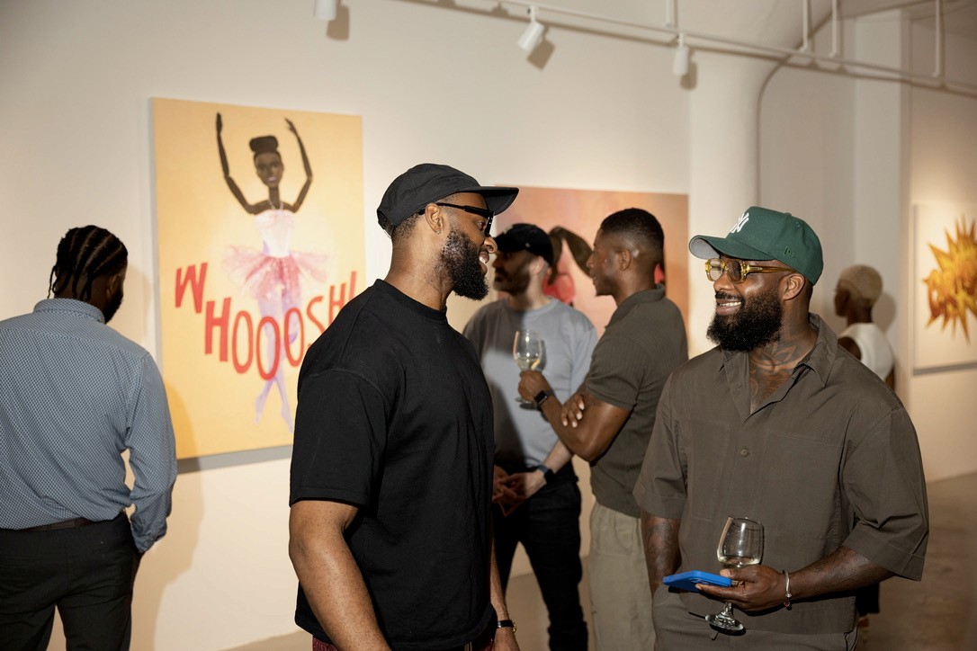 Guests in conversation among the exhibited paintings