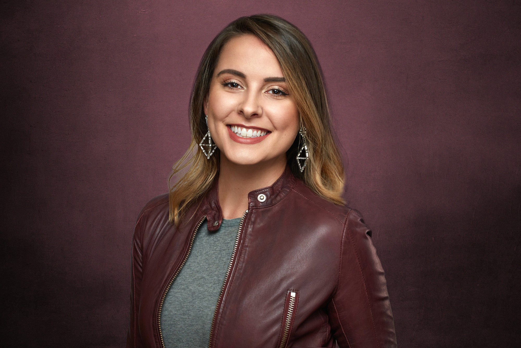 Vibrant studio headshot of woman with long silver curly hair