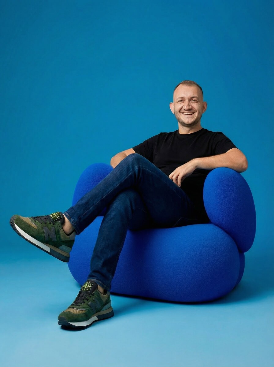 Image of Senior UX designer sitting on blue beanbag chair, representing expertise in UX design and strategy.