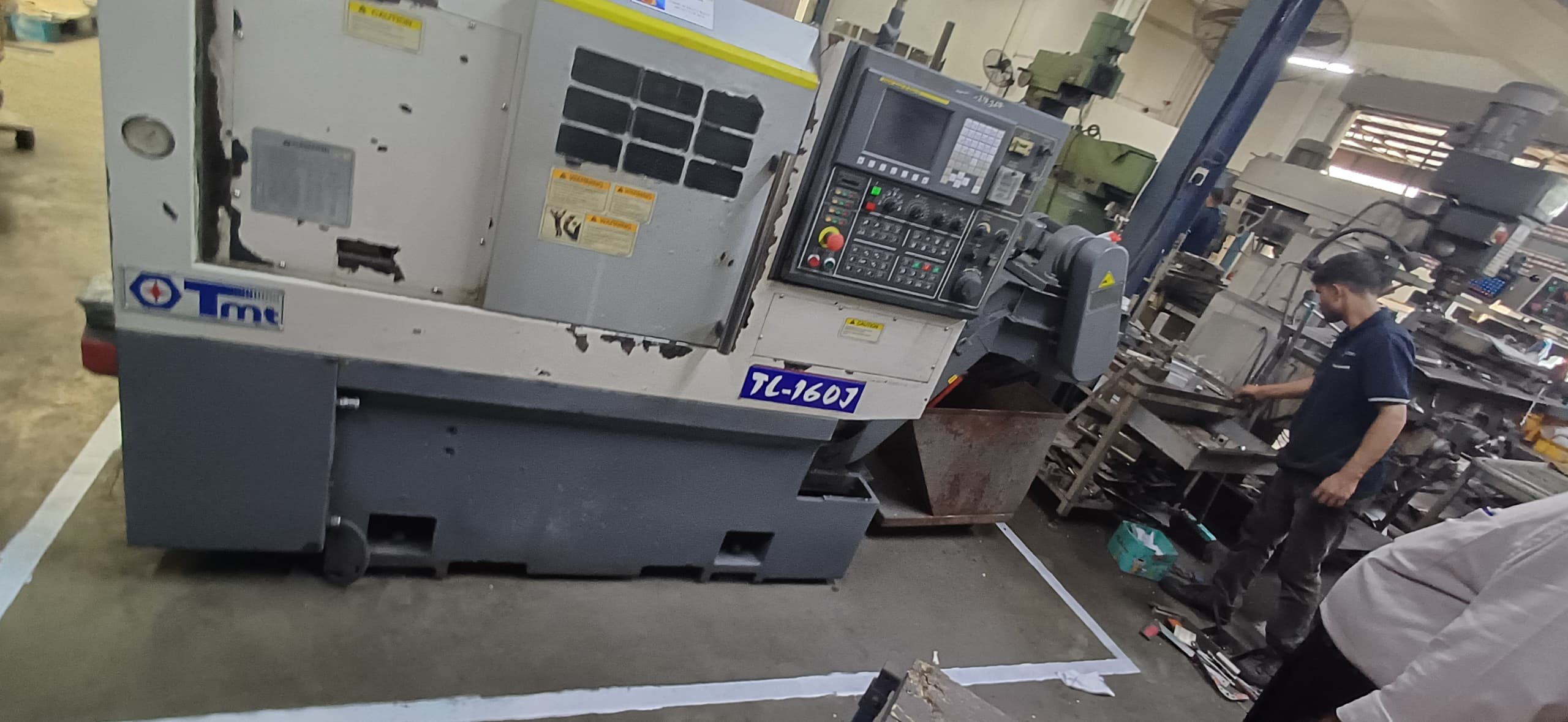 After 5S implementation: Technician operating the CNC lathe machine, showing a clean and standardized workstation in the Malaysia factory.