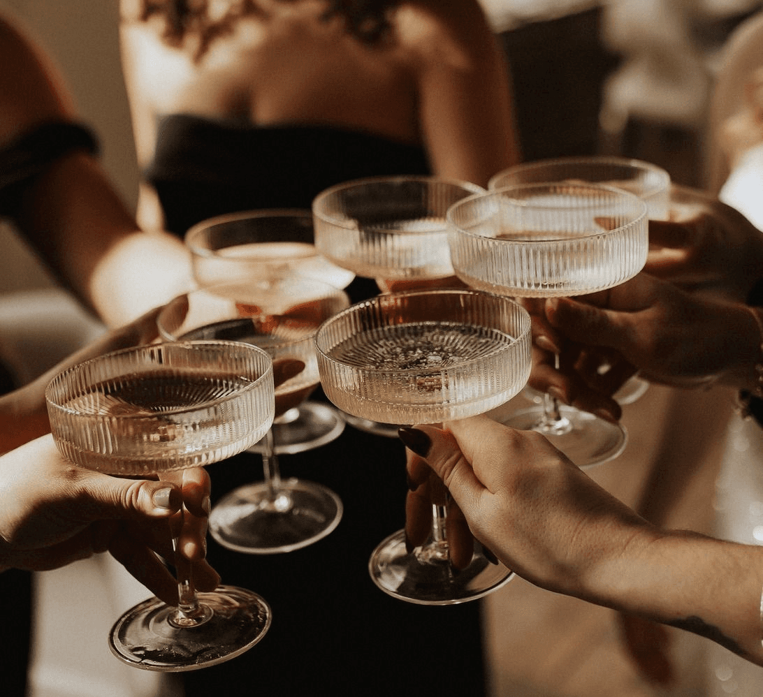 Guests raising champagne coupes at an intimate, elevated wine gathering—reflecting SNOOTI’s private wine membership and sommelier-curated experiences.