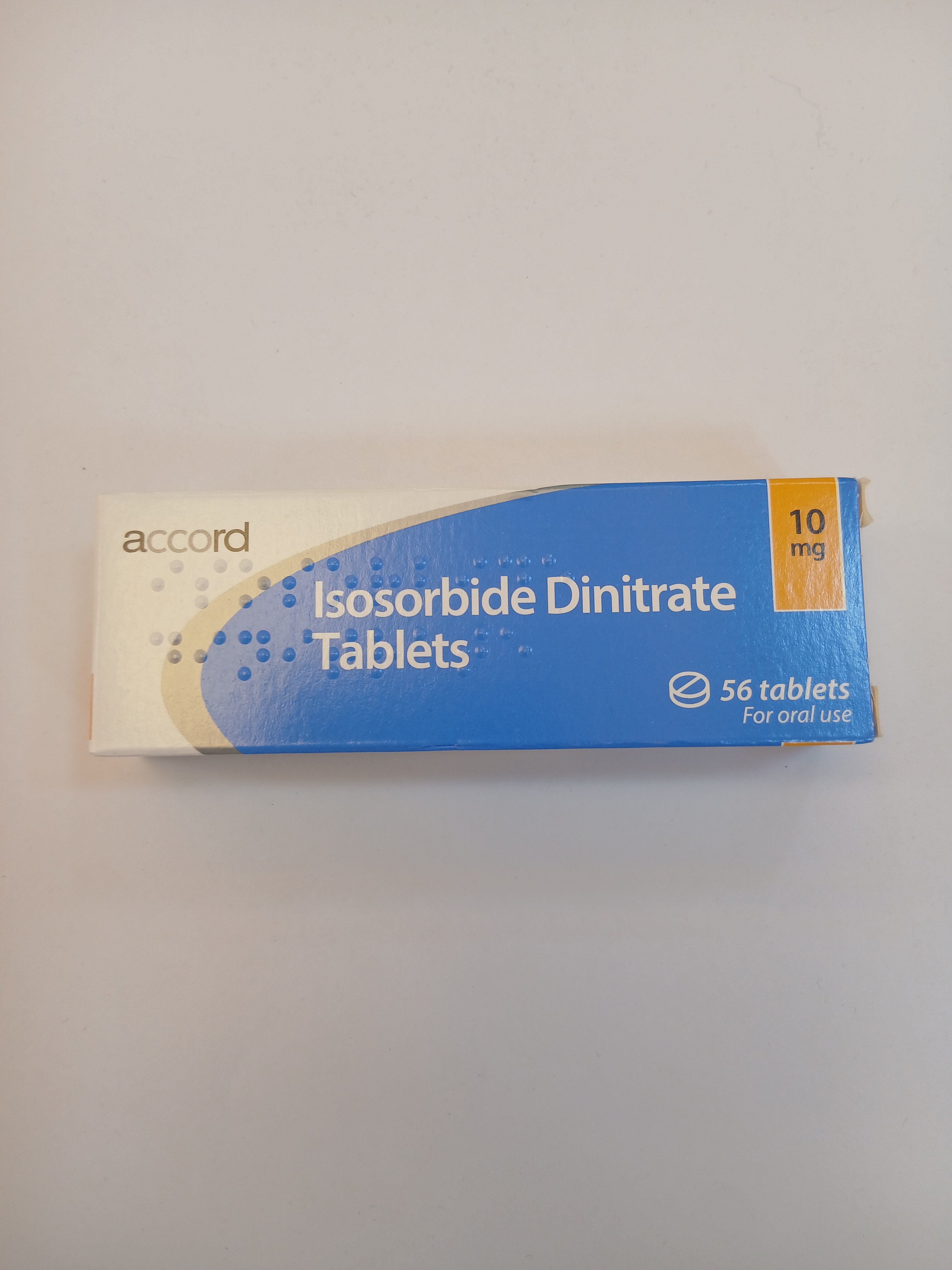 A white and blue cardboard strip packaging containing a blister pack of ten small, white tablets, labeled with text and placed on a plain light background.