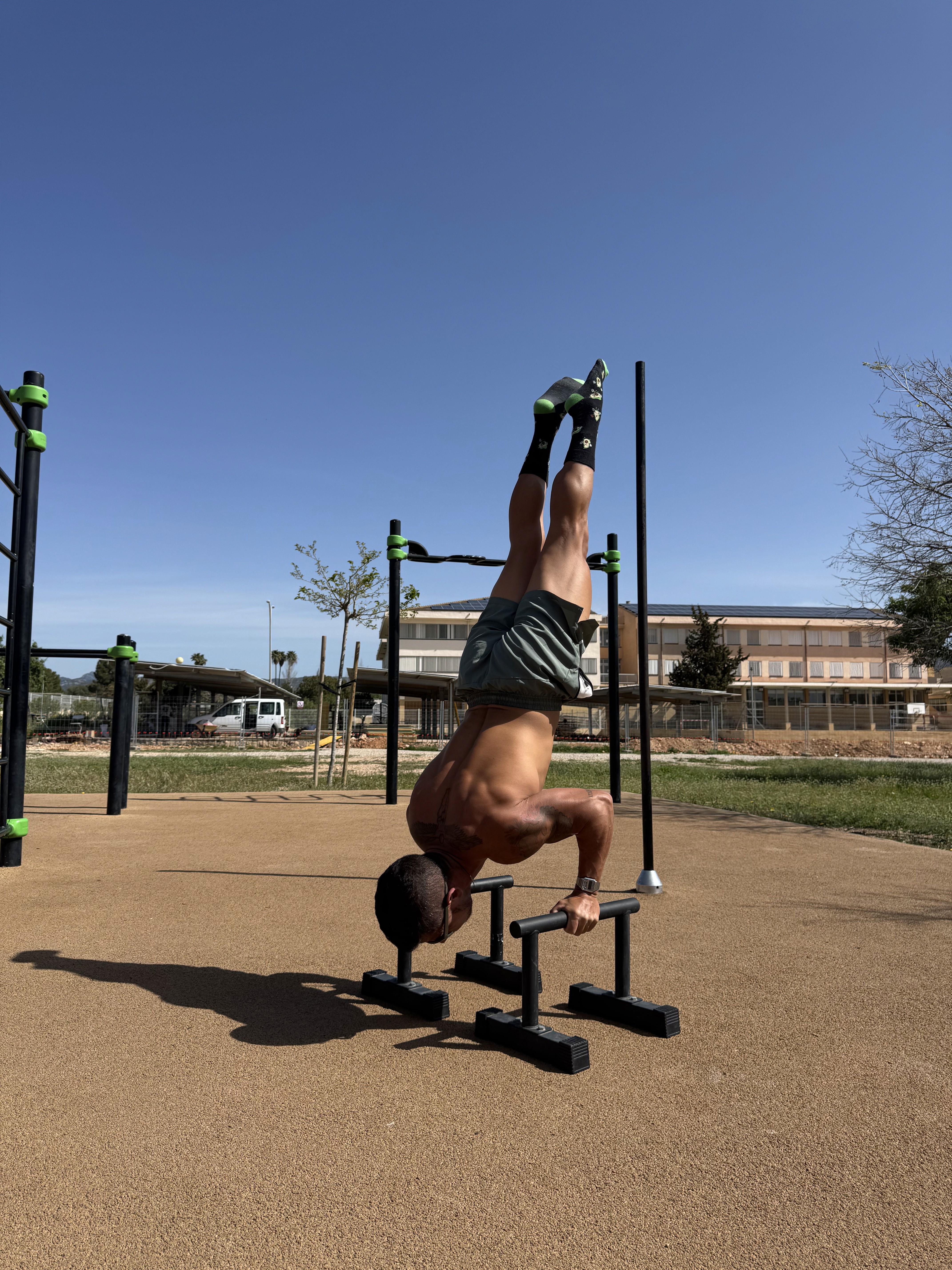 Daniel haciendo un "hand stand" en paralelas, en el parque de calistenia