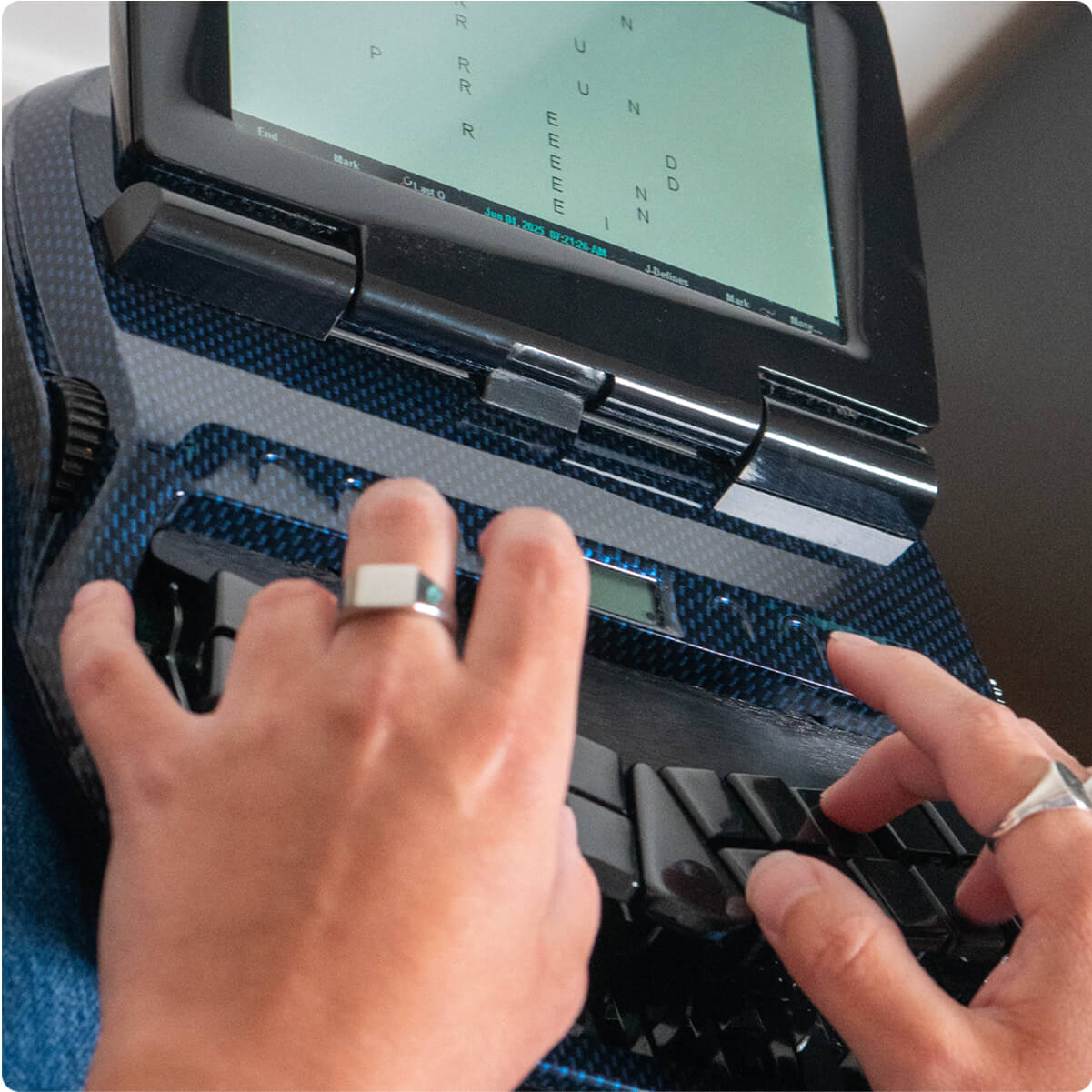 Zoom sur les mains d’une sténotypiste en train de travailler sur une machine de transcription