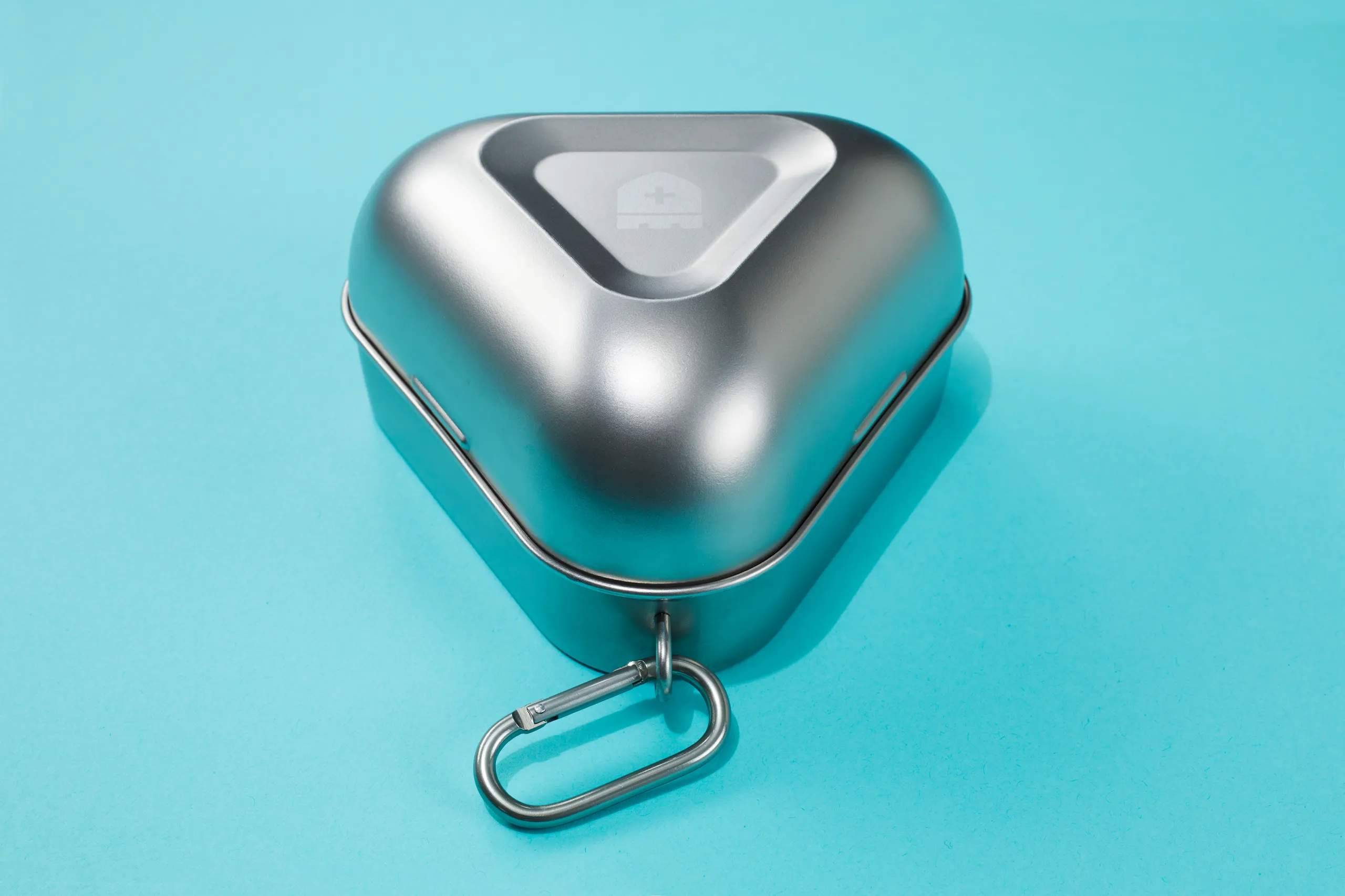 Close-up of a silver CastleGrade reusable PPE case with attached carabiner