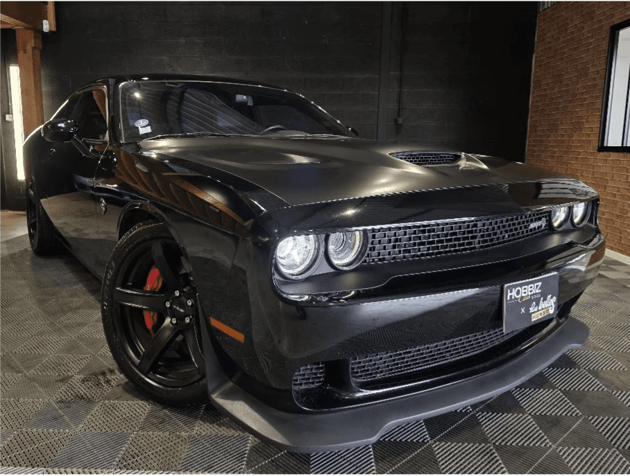 A fast black sports car races down the highway.