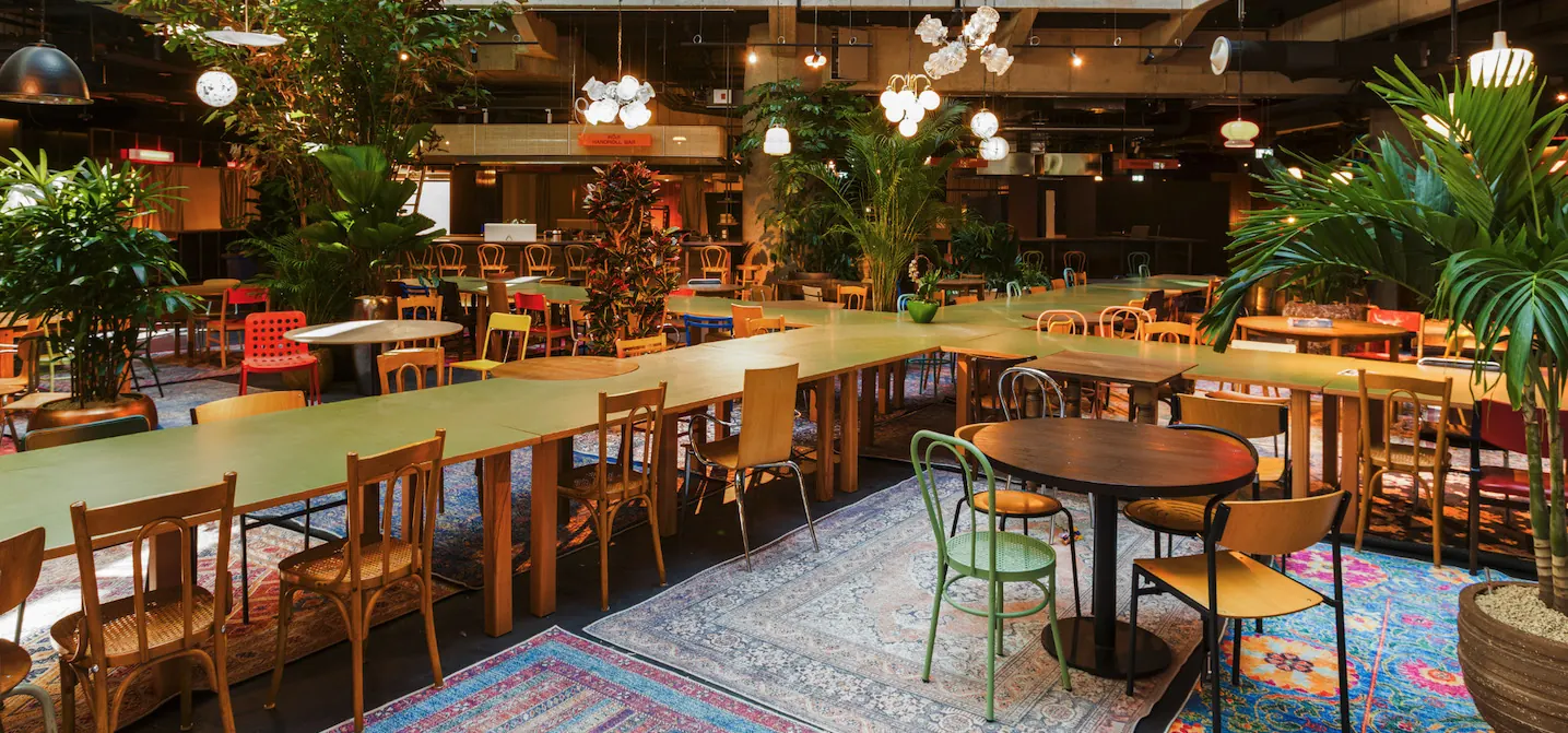 Sitzbereich mit Pflanzen und Teppichen in der Food-Halle im Nobelquartier Neukölln