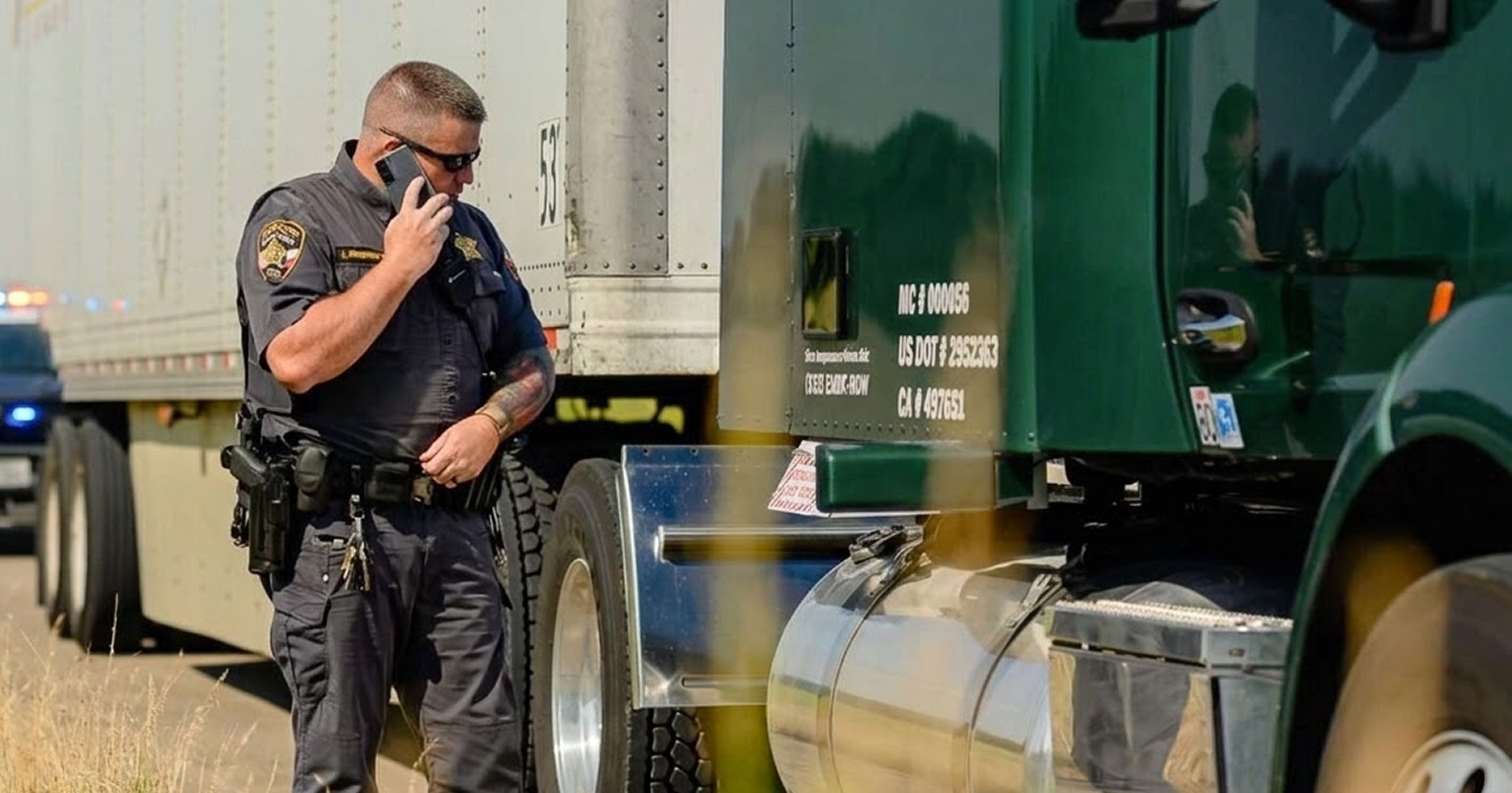 Image of several trucks parked at a truck stop with one truck driving away