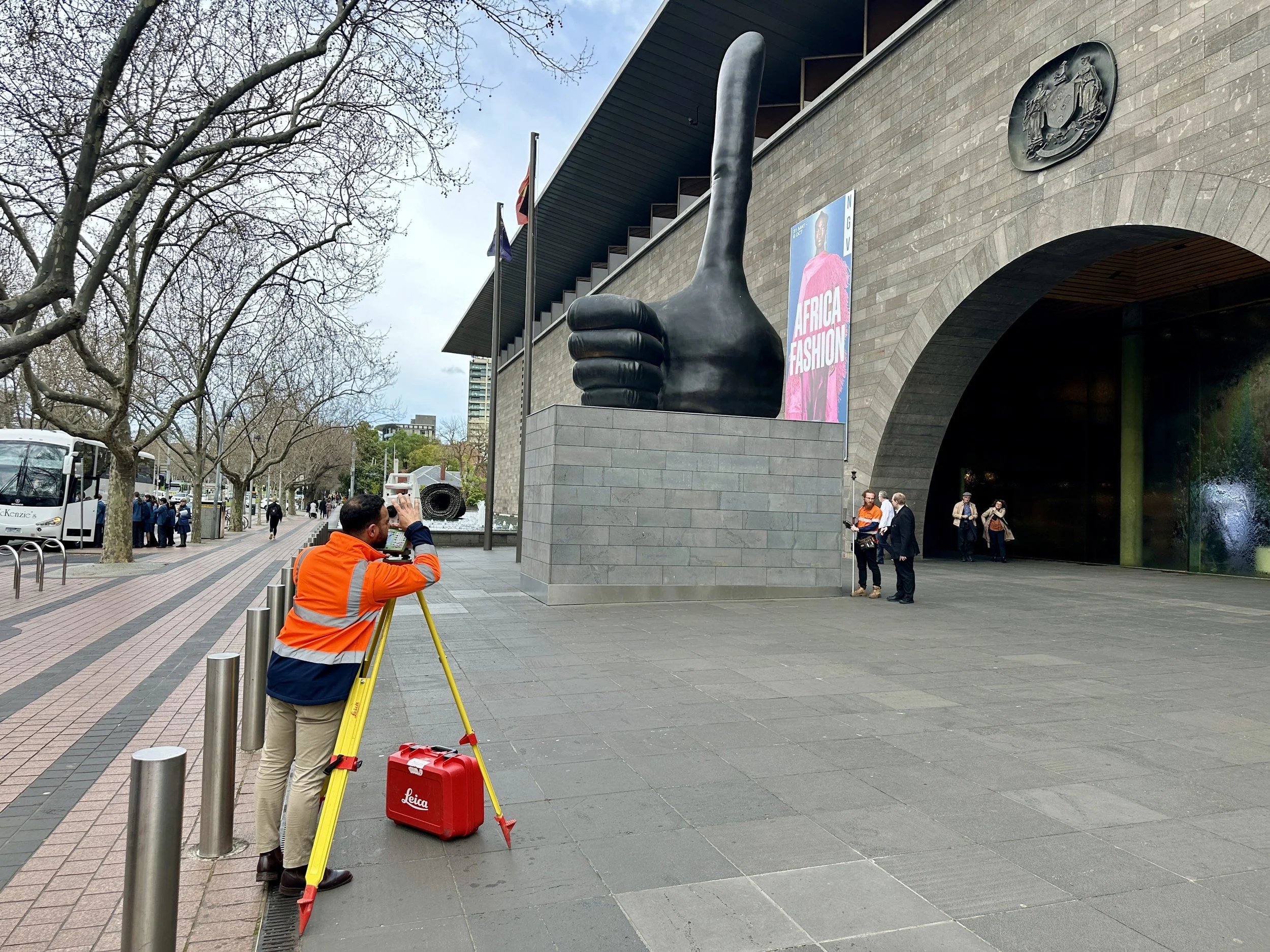 Licensed surveyor in uniform with professional surveying equipment, working outside the National Gallery of Victoria