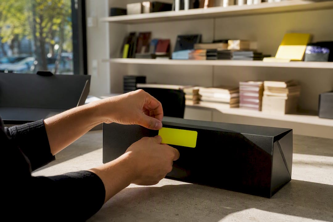 Hands applying coupon sticker to product package