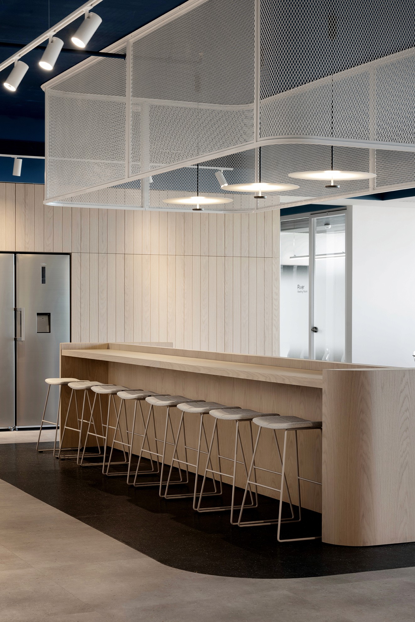 פרט נגרות: דלפק בר מעץ אלון טבעי בייצור Custom Made עם קווים מעוגלים (Radius) לריכוך המראה התעשייתי של החלל