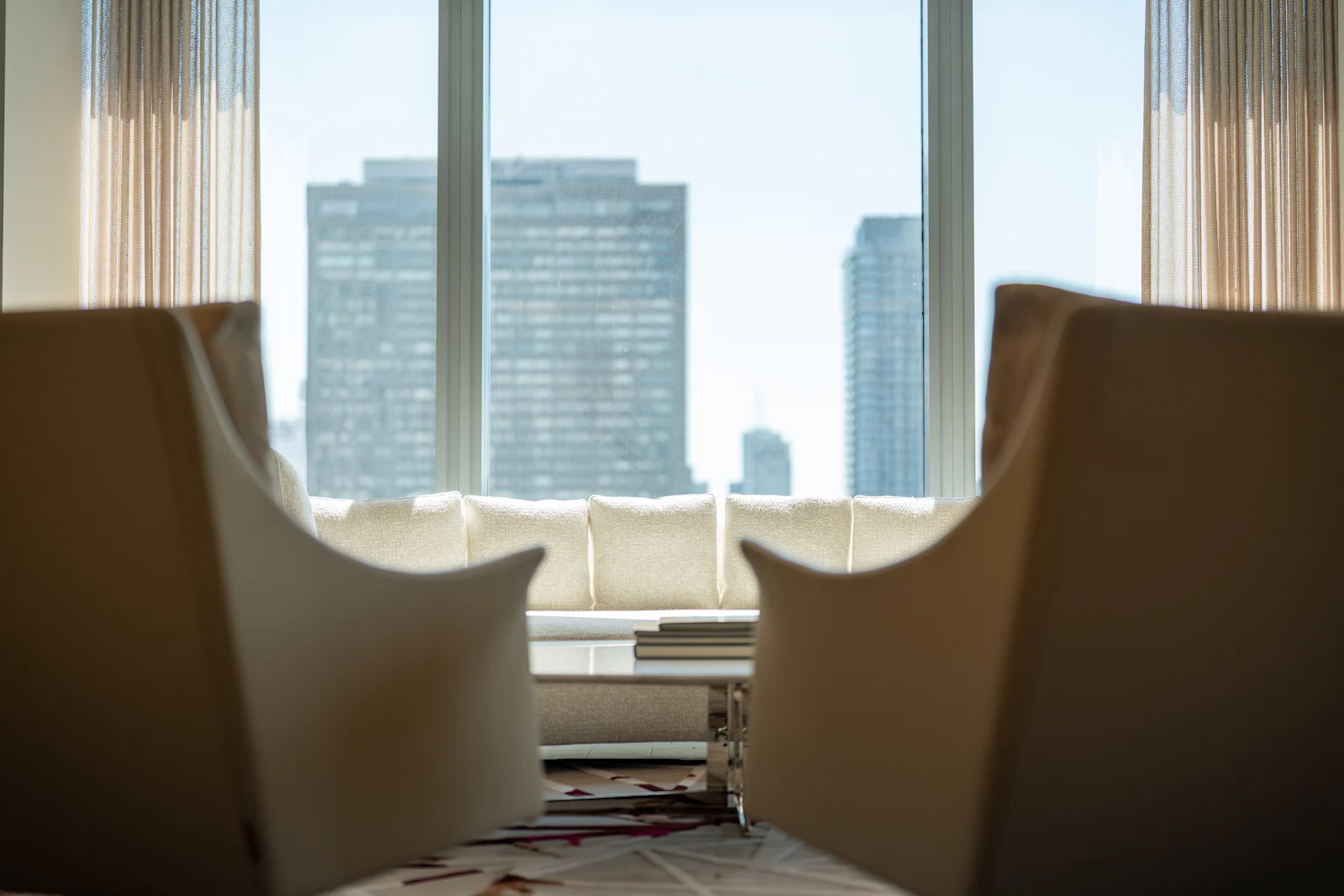 Two chairs facing a window with city buildings