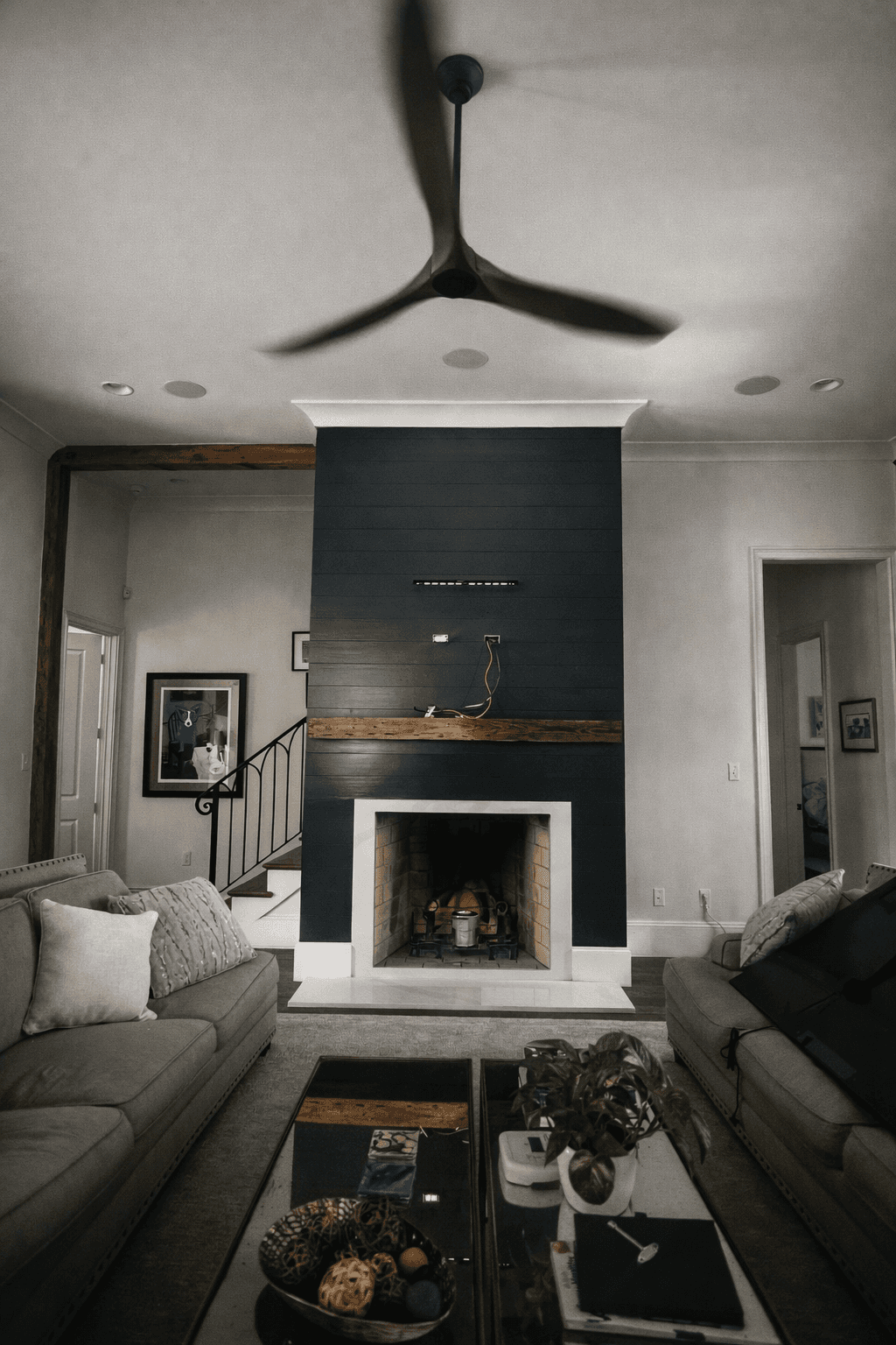 A modern house with large windows and a flat roof, surrounded by greenery against a clear blue sky.