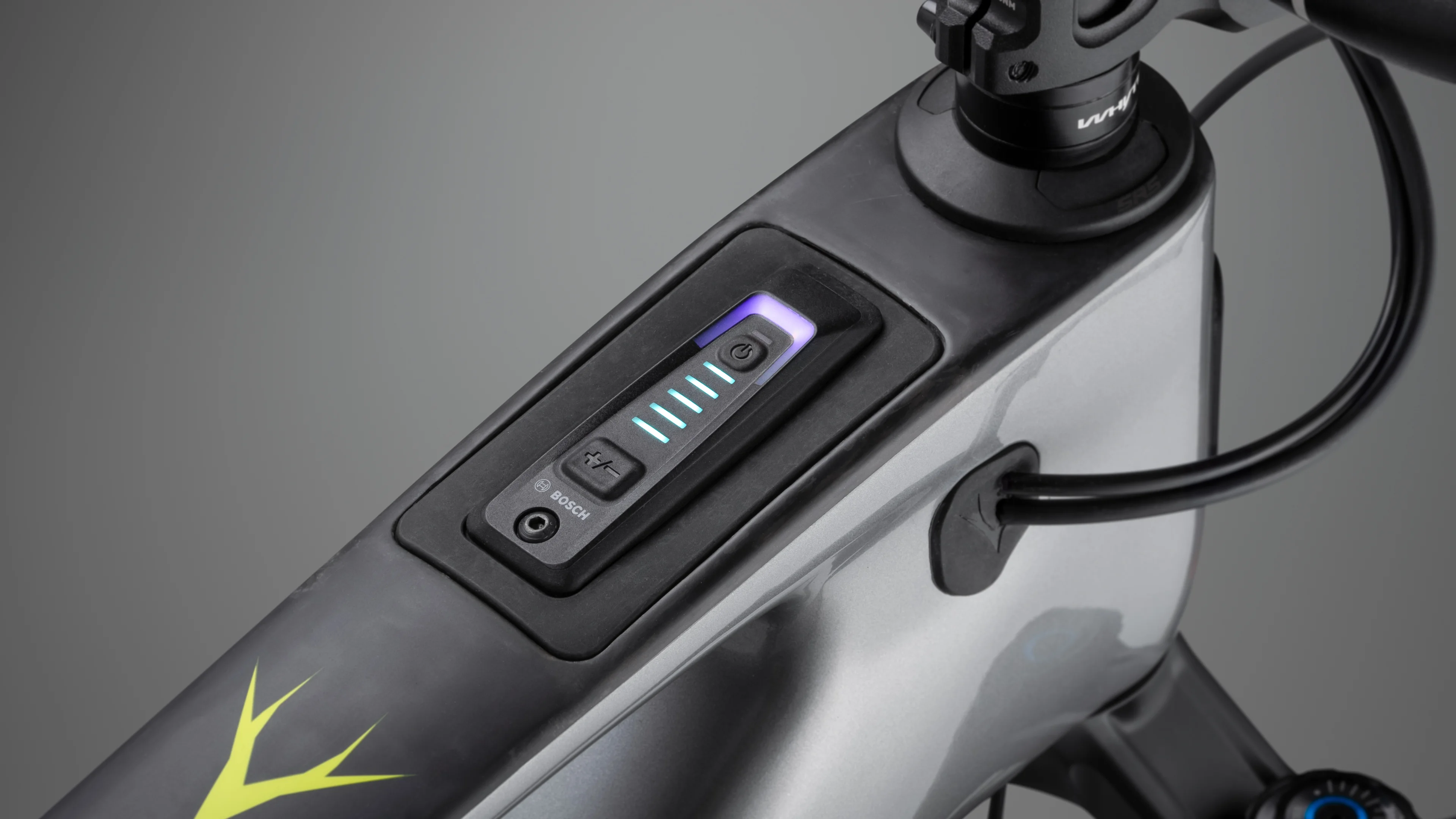 Close-up of Elyte electric mountain bike top tube showing integrated power display, control interface, and clean embedded battery system design.