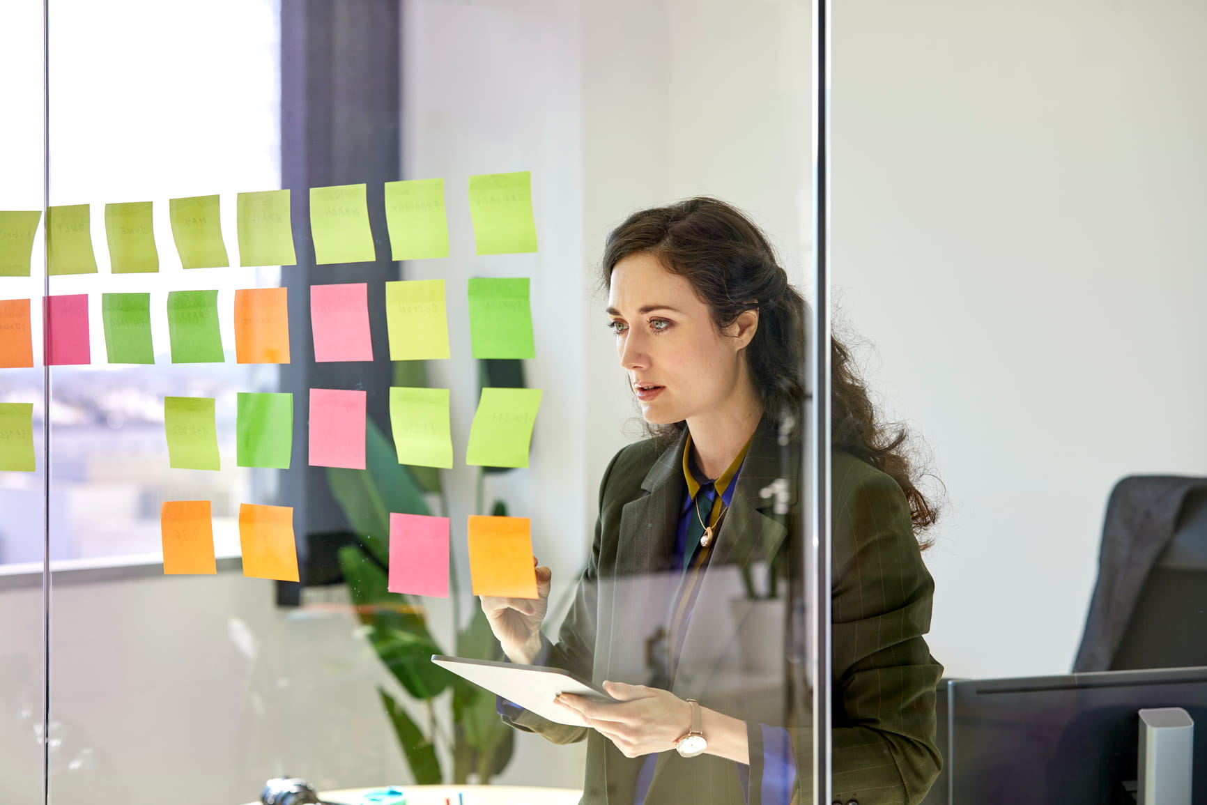 Coworker arranging meeting notes on wall