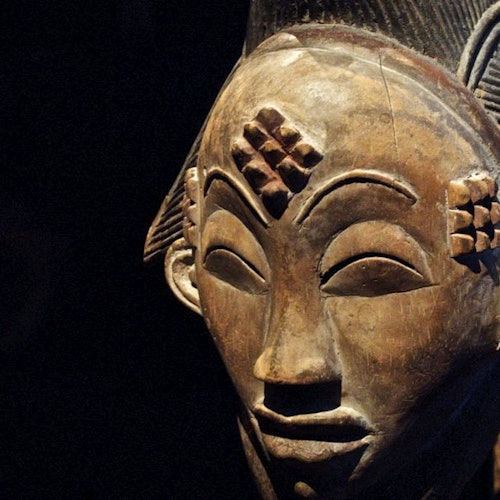 黑色背景下,雕刻着几何图案的木雕面具,在额头和面颊上。