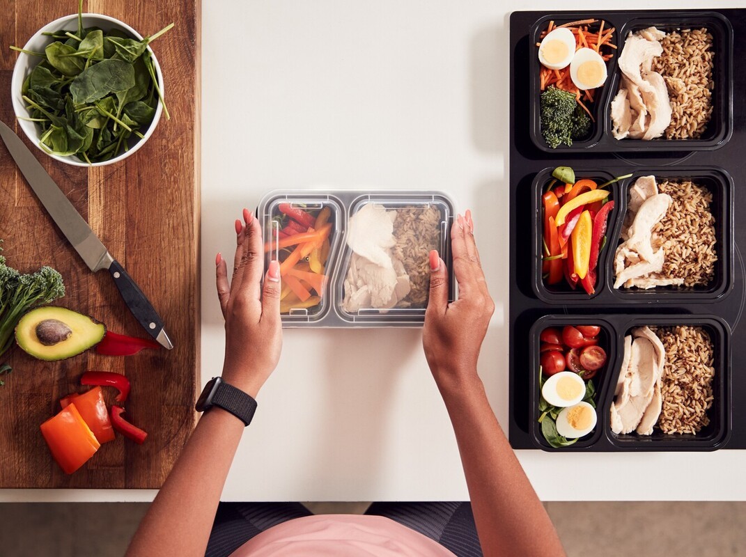 woman doing meal prep to make healthy meals to complement the best sauna temperature for weight loss workouts