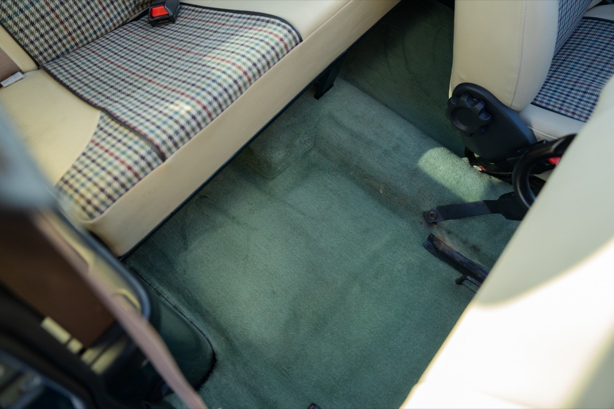 Interior view of a vehicle showing a clean floor with seating on either side.