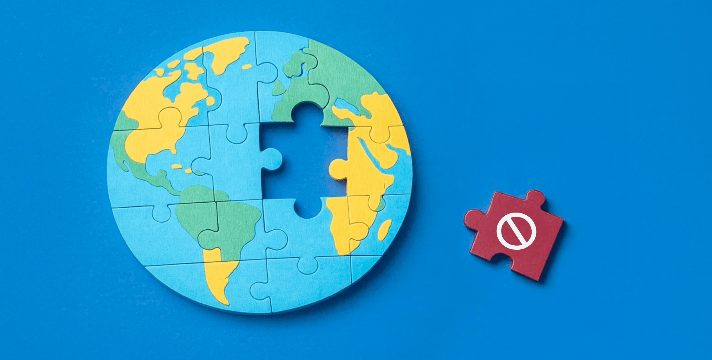 A globe made of puzzle pieces, with one missing piece. Next to it is a puzzle piece with a "prohibited" emoji on it. The background is blue.