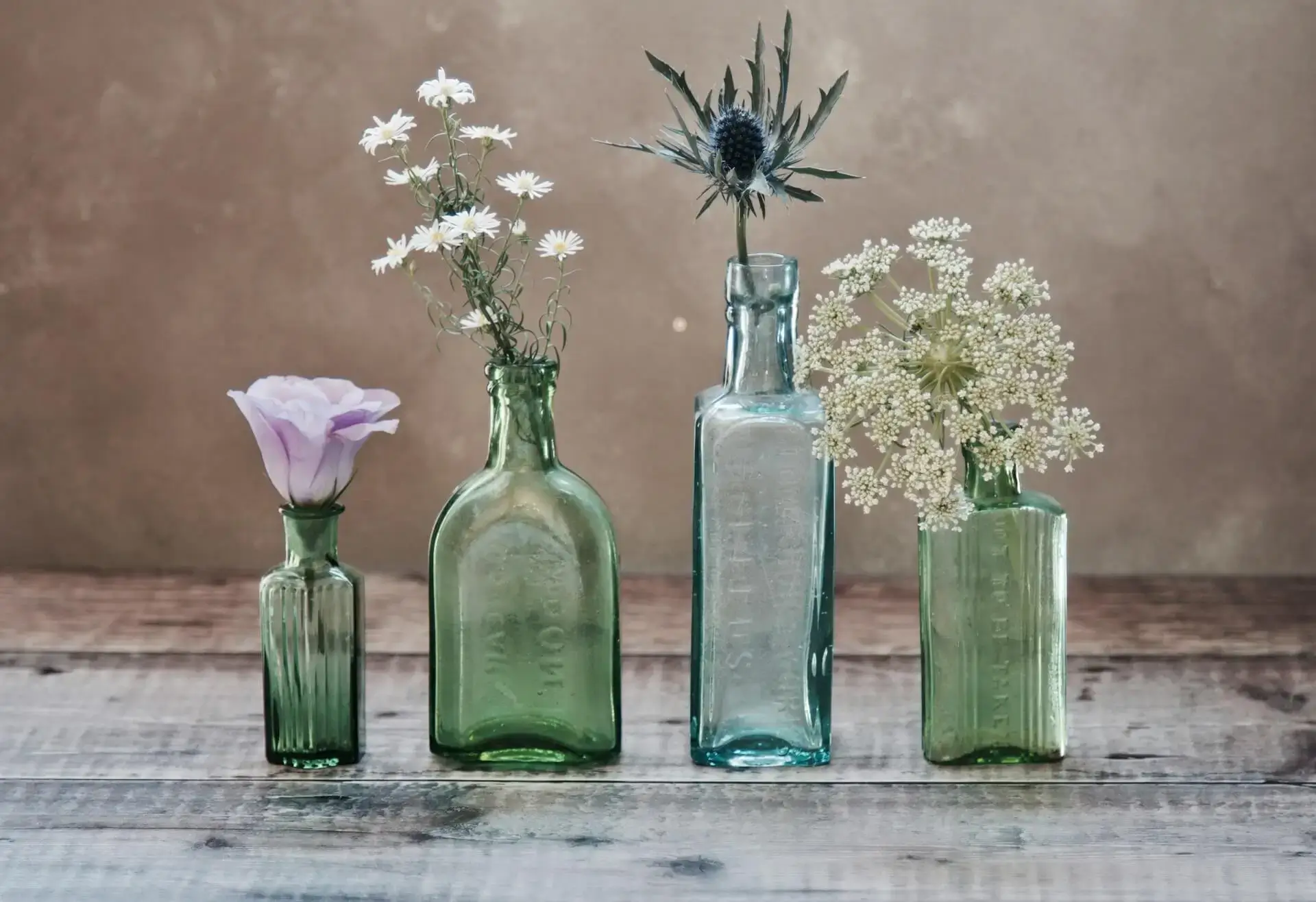 4 verschiedene gepflückte blumen in durchsichtigen trüben glasvase